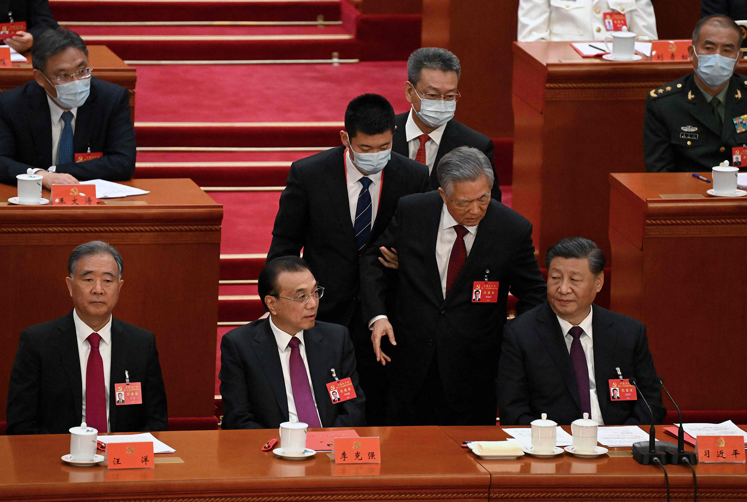 China's President Xi Jinping sits besides Premier Li Keqiang as former president Hu Jintao is assisted to leave from the closing ceremony of the 20th China's Communist Party's Congress at the Great Hall of the People in Beijing on Oct. 22.