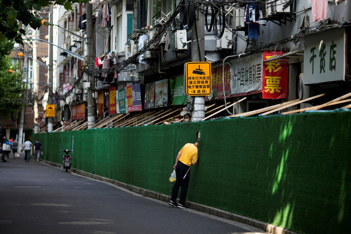 A man looks in through a gap in a barrier in a residential area, after the lockdown placed to curb the COVID-19 outbreak was lifted in Shanghai, China on June 7.