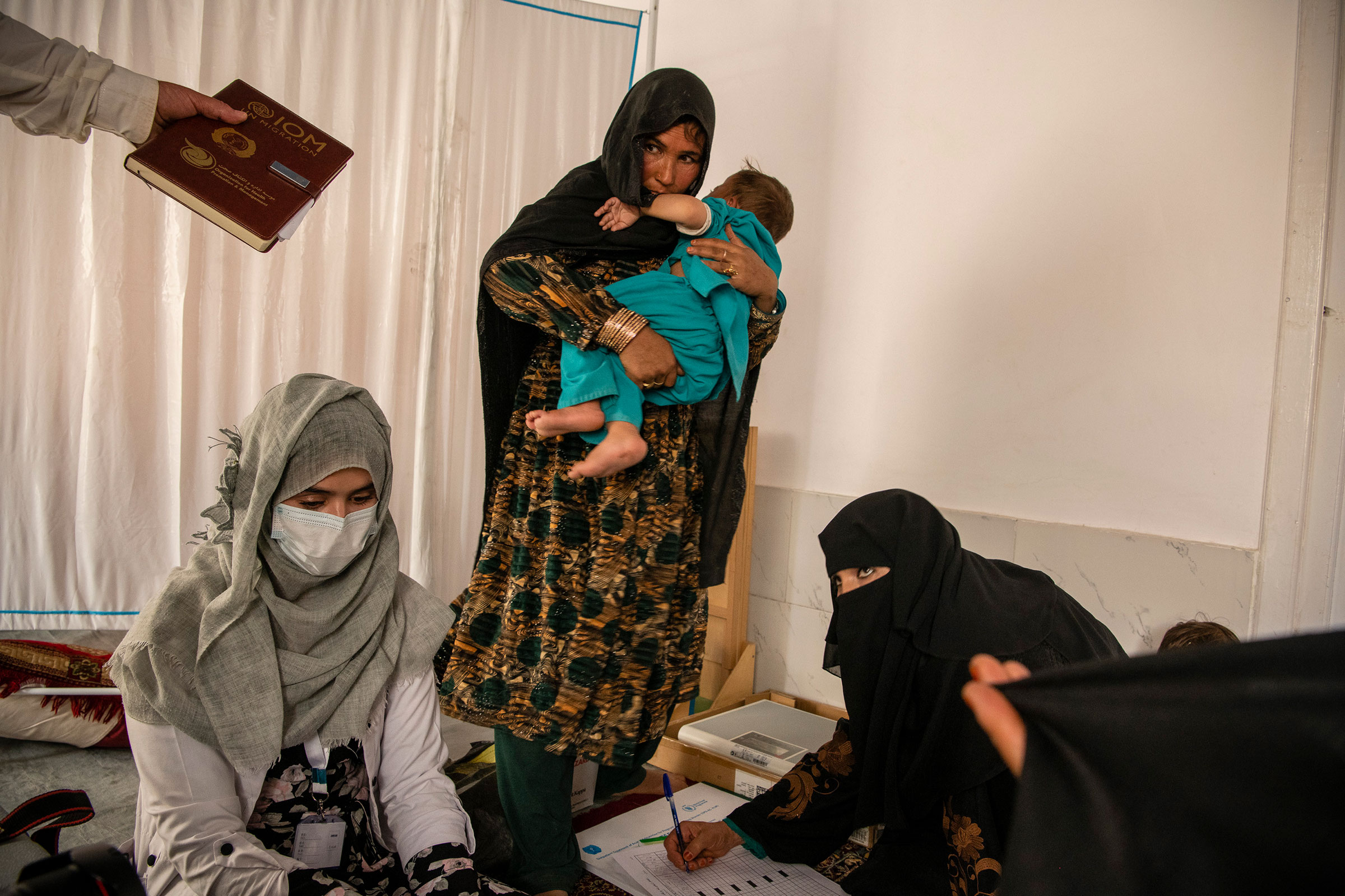 Lahorah, 30, with her year-old son, Safiullah, at a mobile clinic set up by UNICEF in the remote village of Alisha, in Wardak Province, Afghanistan, on June 11. The Taliban's rulers have reinstituted an emirate governed by a strict interpretation of Islamic law and issued a flood of edicts curtailing women's rights, institutionalizing patriarchal customs, restricting journalists and effectively erasing many vestiges of an American-led occupation and nation-building effort. (Kiana Hayeri—The New York Times/Redux)