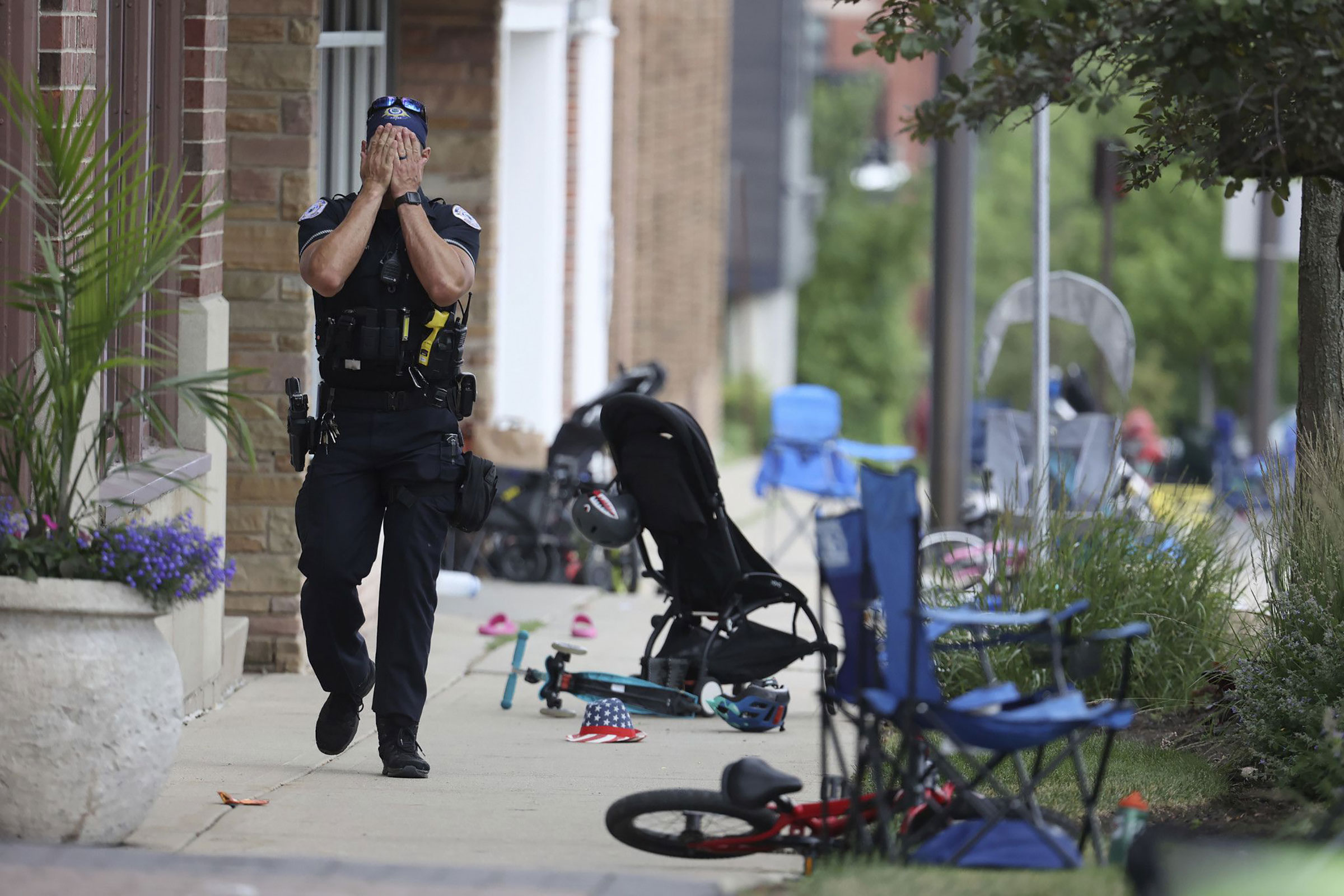 A Lake County police officer walks down Central Avenue in Highland Park, Ill. on July 4 after a shooter fired on the northern suburb's Fourth of July parade. At least six people were killed and at least two dozen injured. (Brian Cassella—Chicago Tribune/Tribune News Service/Getty Images)