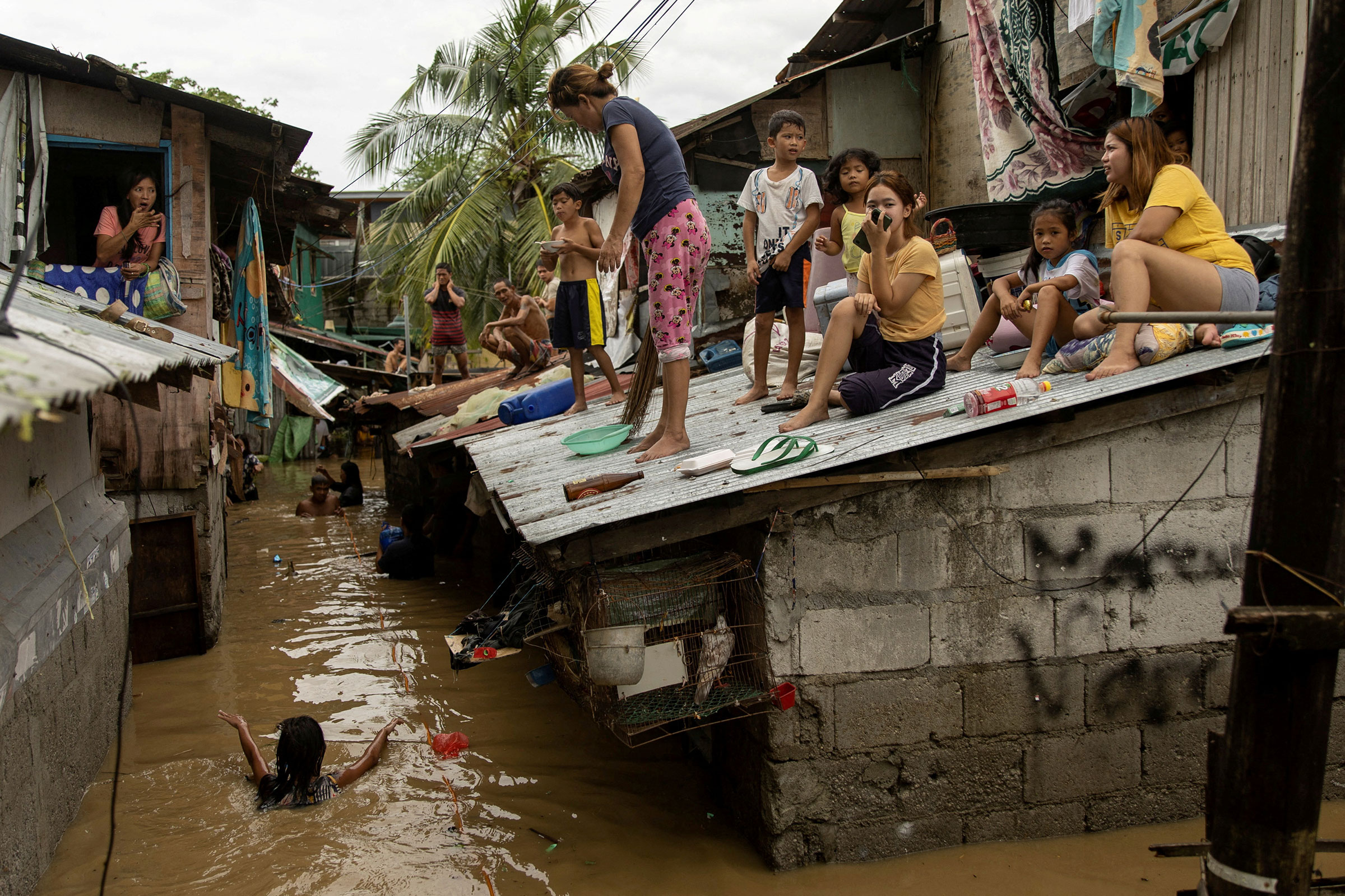 Residents wait on the roof of their homes for the flooding to subside after Super Typhoon Noru, in San Miguel, Bulacan province, Philippines, on Sept. 26. (Eloisa Lopez—Reuters)