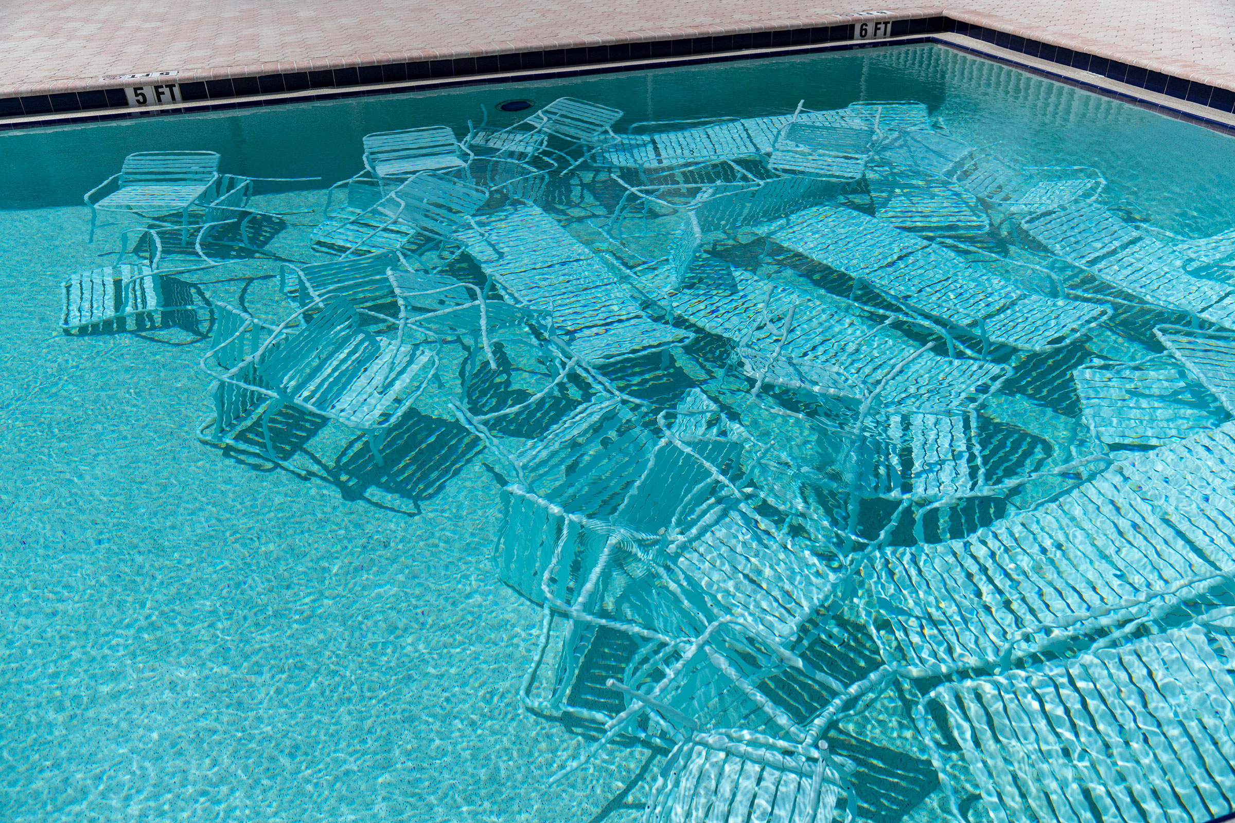 Pool chairs are stored under water in preparation for the arrival of Hurricane Ian at Harbourside Condominiums in South Pasadena, Fla. on Sept. 26. (Martha Asencio-Rhine—Tampa Bay Times/ZUMA)
