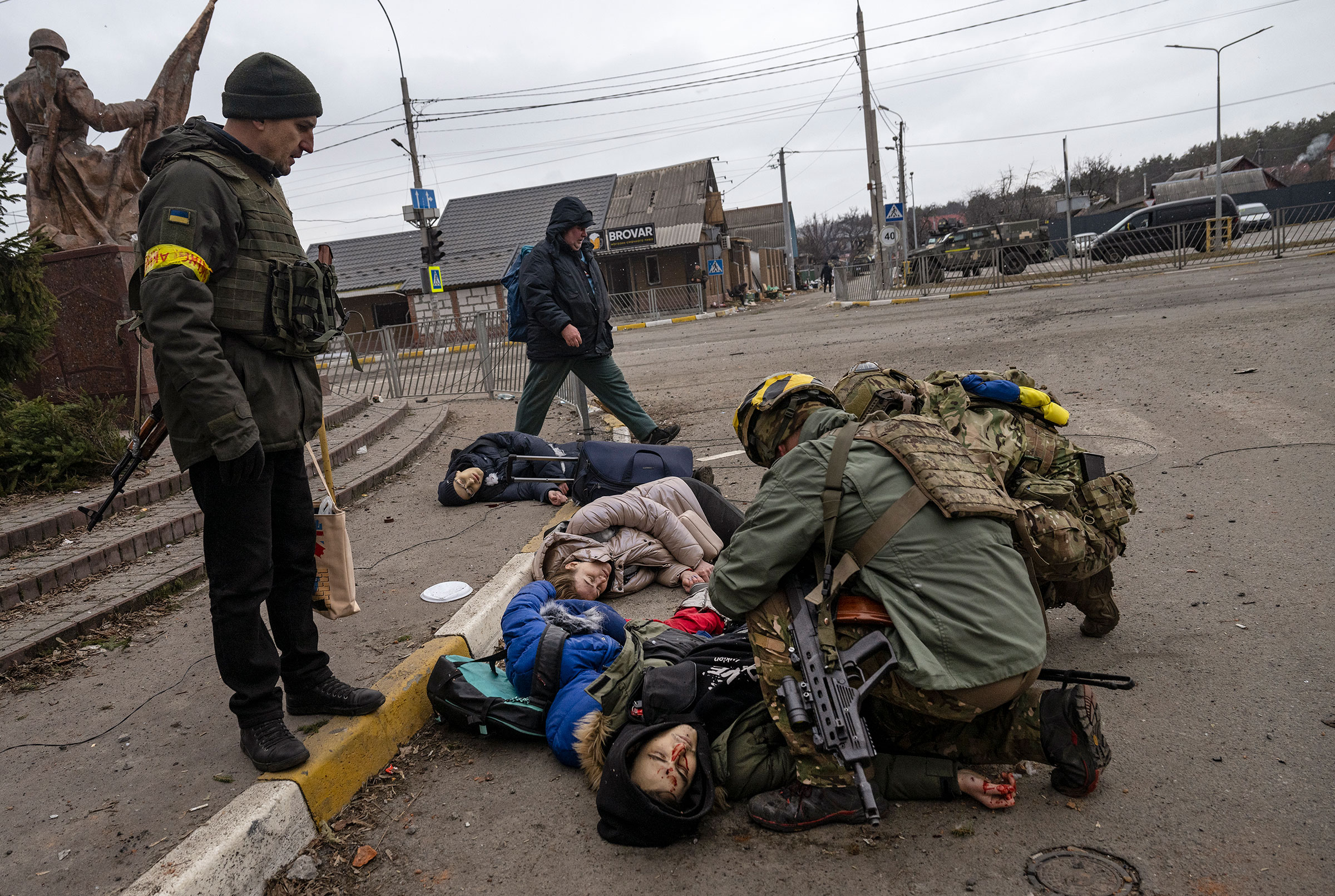 Ukrainian soldiers attend to a group of civilians, including Tetiana Perebyinis and her two children, who were mortally wounded by a Russian mortar round while they evacuated from Irpin, Ukraine, on March 6. A volunteer assisting the family was also killed.