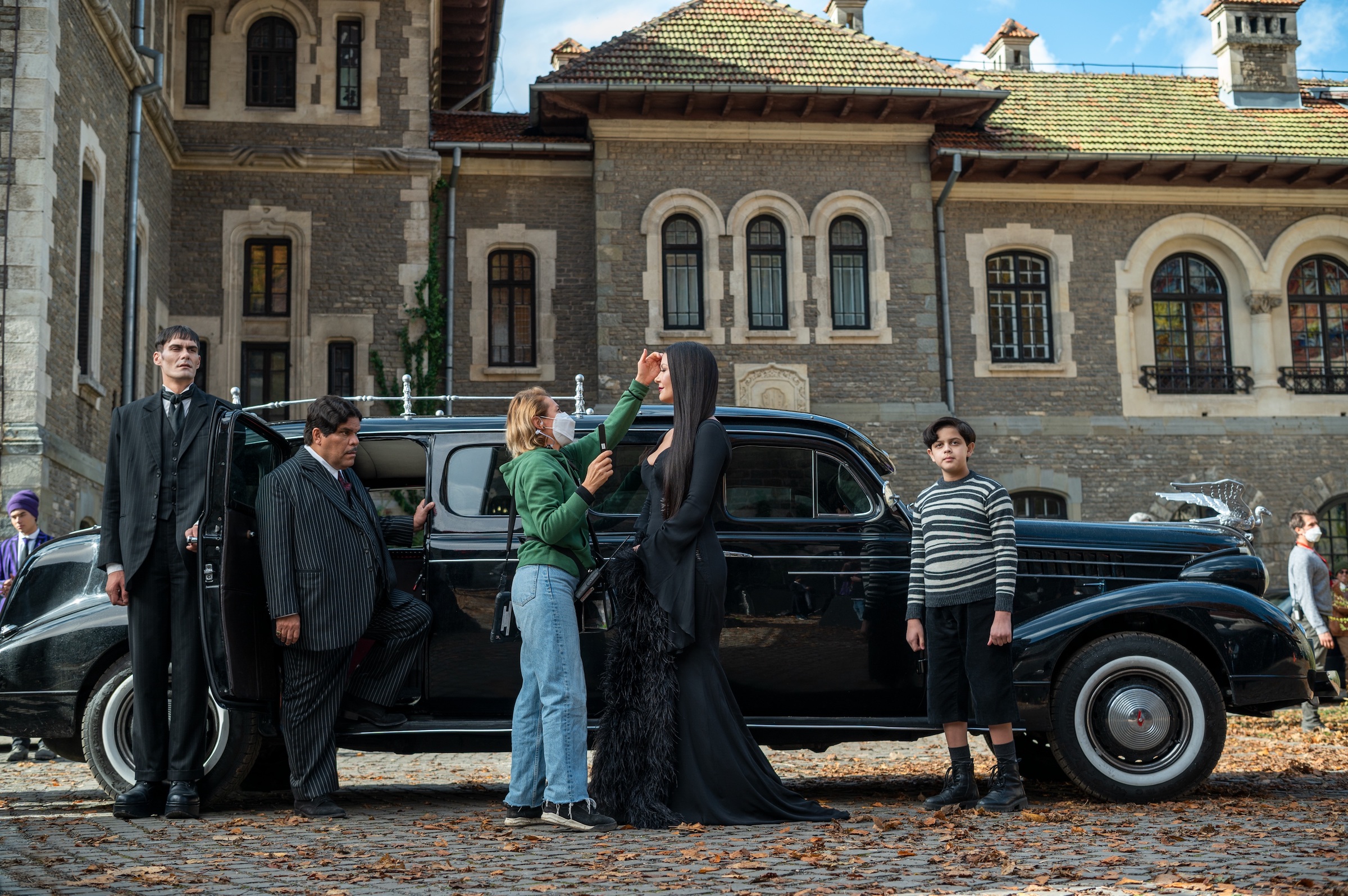 The butler Lurch (George Burcea), Gomez (Luis Guzmán), Morticia (Catherine Zeta-Jones), and Pugsley (Issac Ordonez) visit Nevermore Academy for Parents' Weekend. (Vlad Cioplea—Netflix)