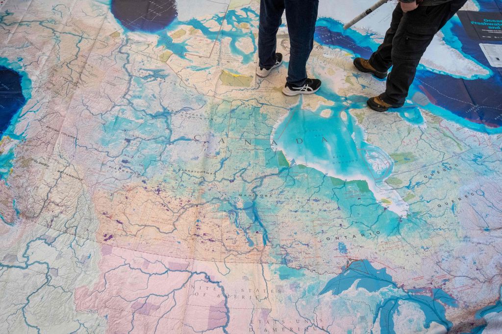People stand on a giant map of Canada during the United the Nations Biodiversity Conference (COP15) in Montreal, Quebec, Canada, on Dec. 17, 2022. (Lars Hagberg—AFP/Getty Images)