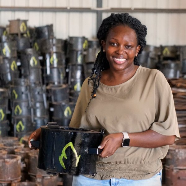 Charlot Magayi, founder of Mukuru Clean Stoves, holding an example of her organization's cleaner-burning cookstoves.