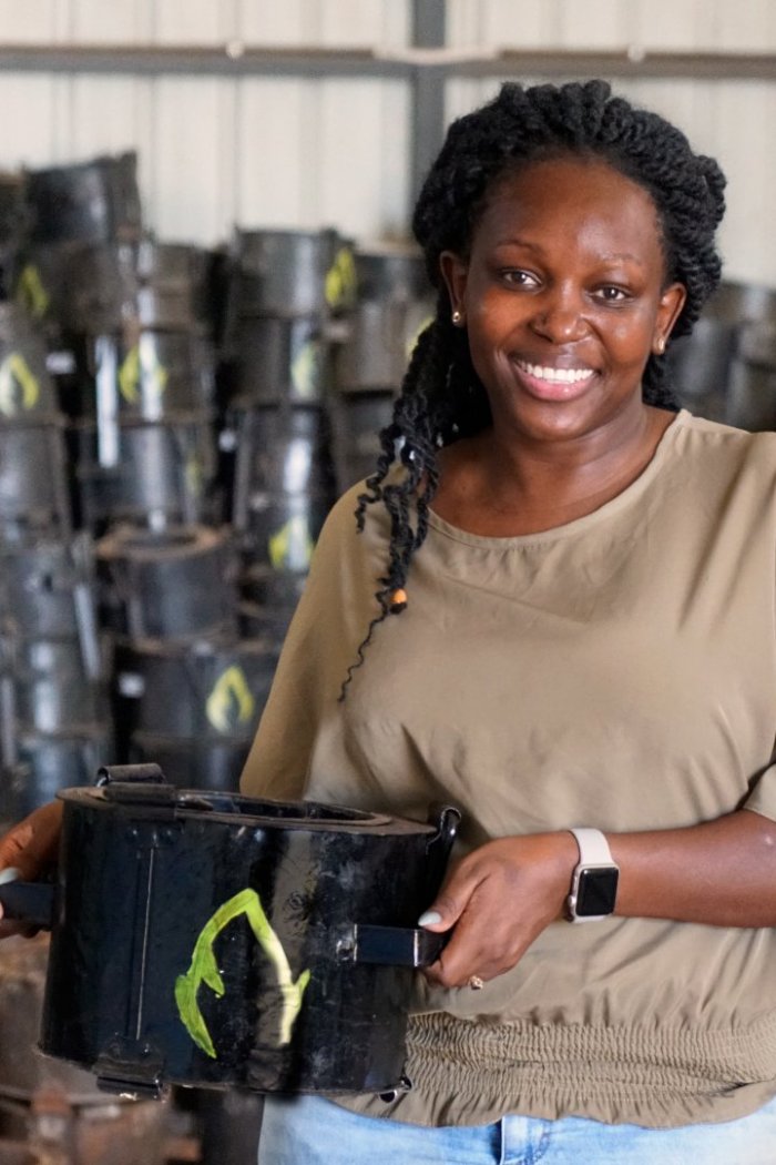 Charlot Magayi, founder of Mukuru Clean Stoves, holding an example of her organization's cleaner-burning cookstoves.