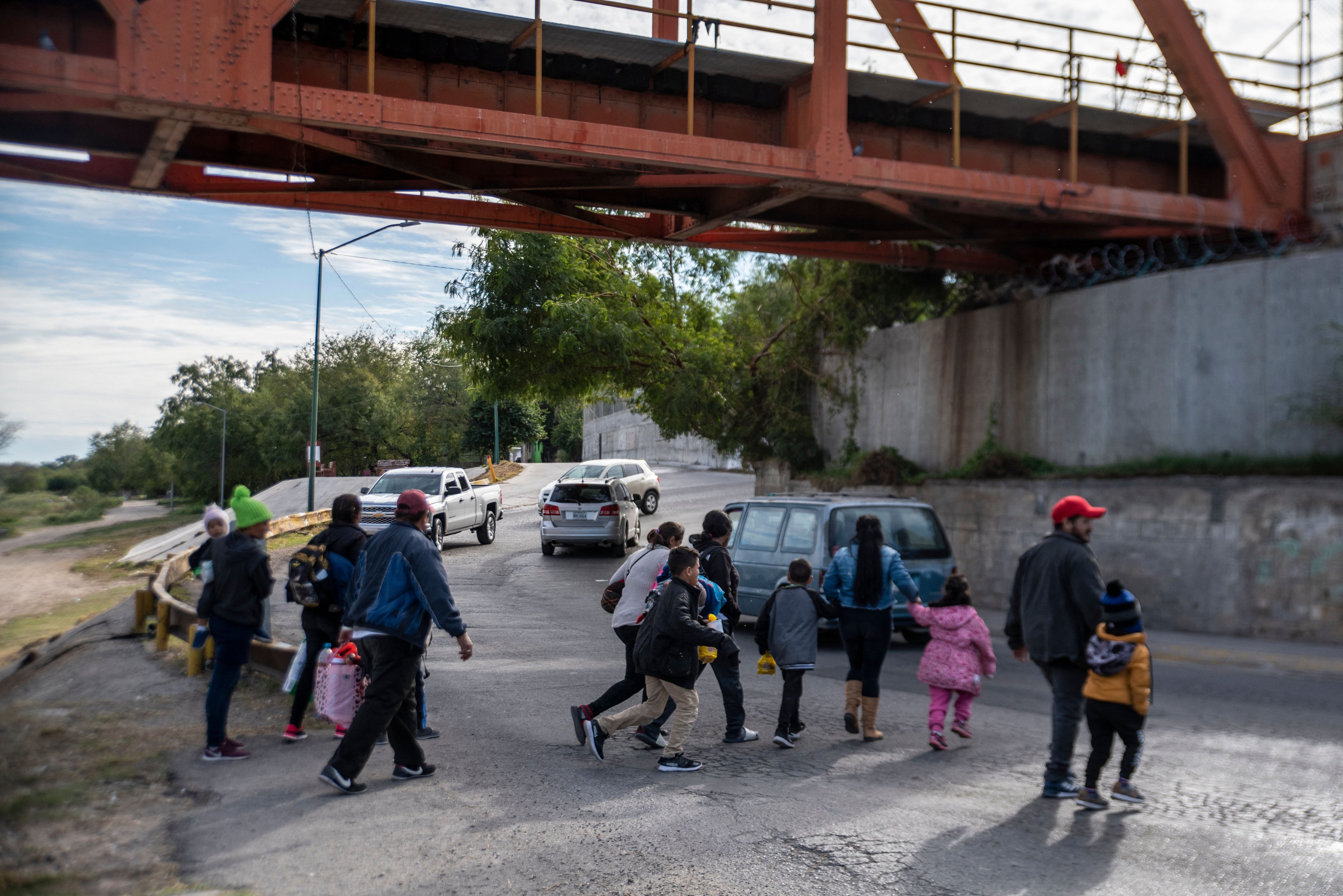 A group of migrants cross the street in Piedras Negras, Mexico on November 16, 2022. (Sergio Flores—AFP/Getty Images)