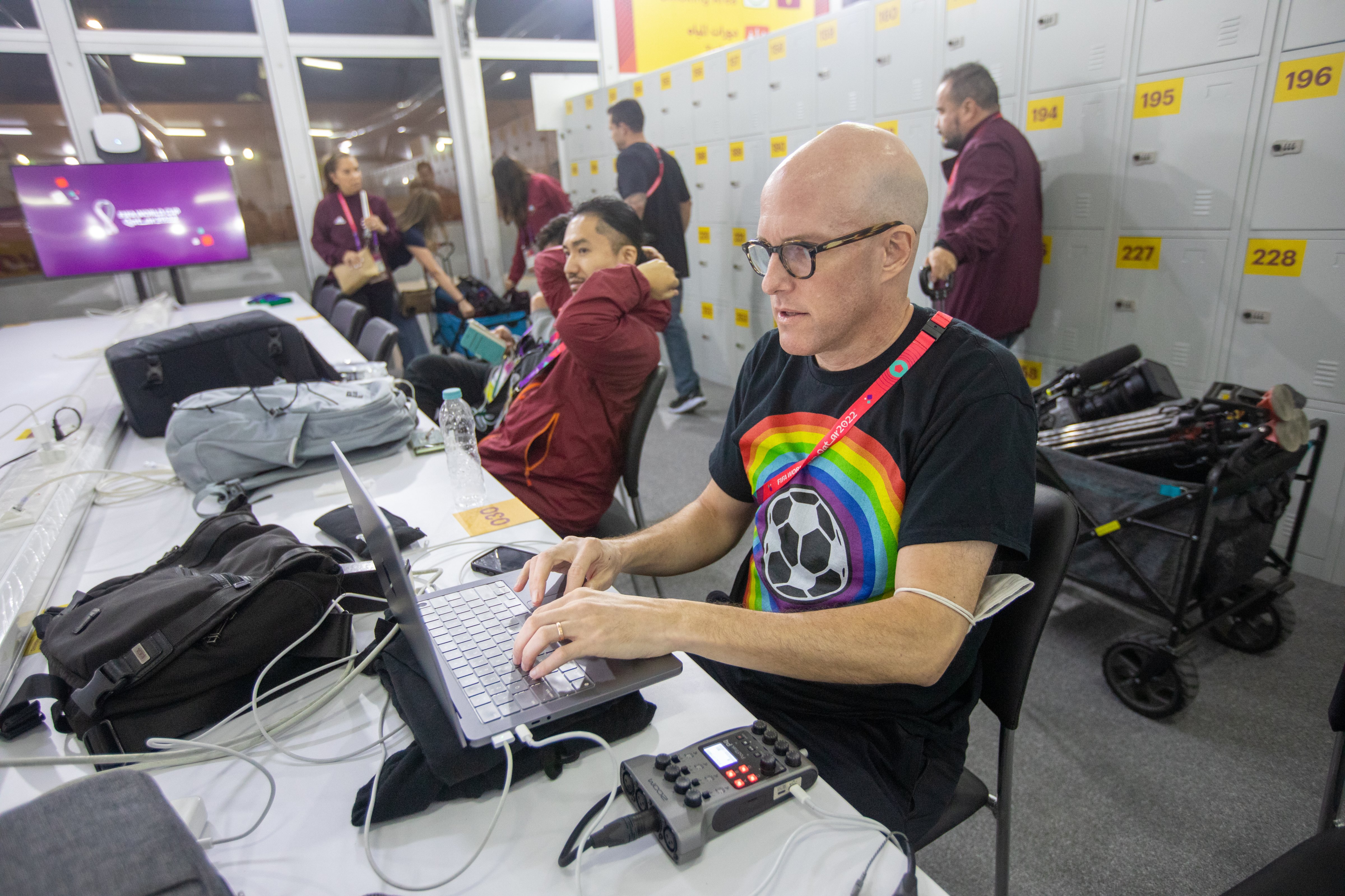Journalist Grant Wahl (right) works in the FIFA Media Center before a FIFA World Cup Qatar 2022 Group B match between Wales and USMNT at Ahmad Bin Ali Stadium on November 21, 2022 in Al Rayyan, Qatar. He had been detained earlier by stadium security for wearing a rainbow-colored t-shirt before later being allowed to enter the stadium. (Doug Zimmerman/ISI Photos—Getty Images)