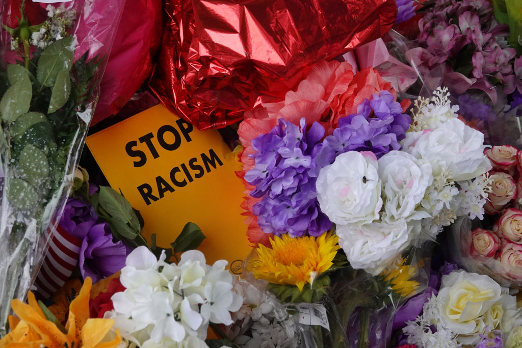 Flowers, candles and mementoes are left at a makeshift memorial outside the Tops market on May 18, 2022 in Buffalo, New York. A gunman opened fire at the store on Saturday, killing 10 people and wounding three others. Police say it's being investigated as a racially motivated hate crime. (Scott Olson–Getty Images)