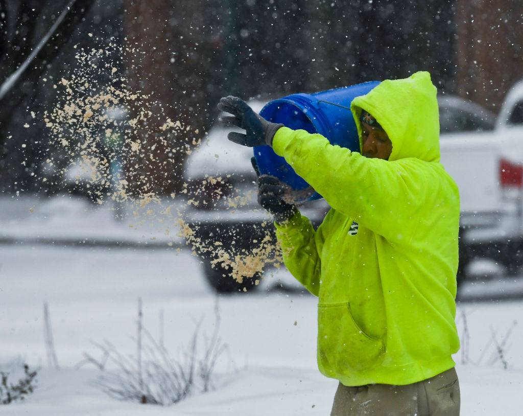 A public works employee spreads salt on sidewalks in Reading, PA during a snowstorm on Feb. 18, 2021. (Ben Hasty—MediaNews Group/Reading Eagle/Getty Images)