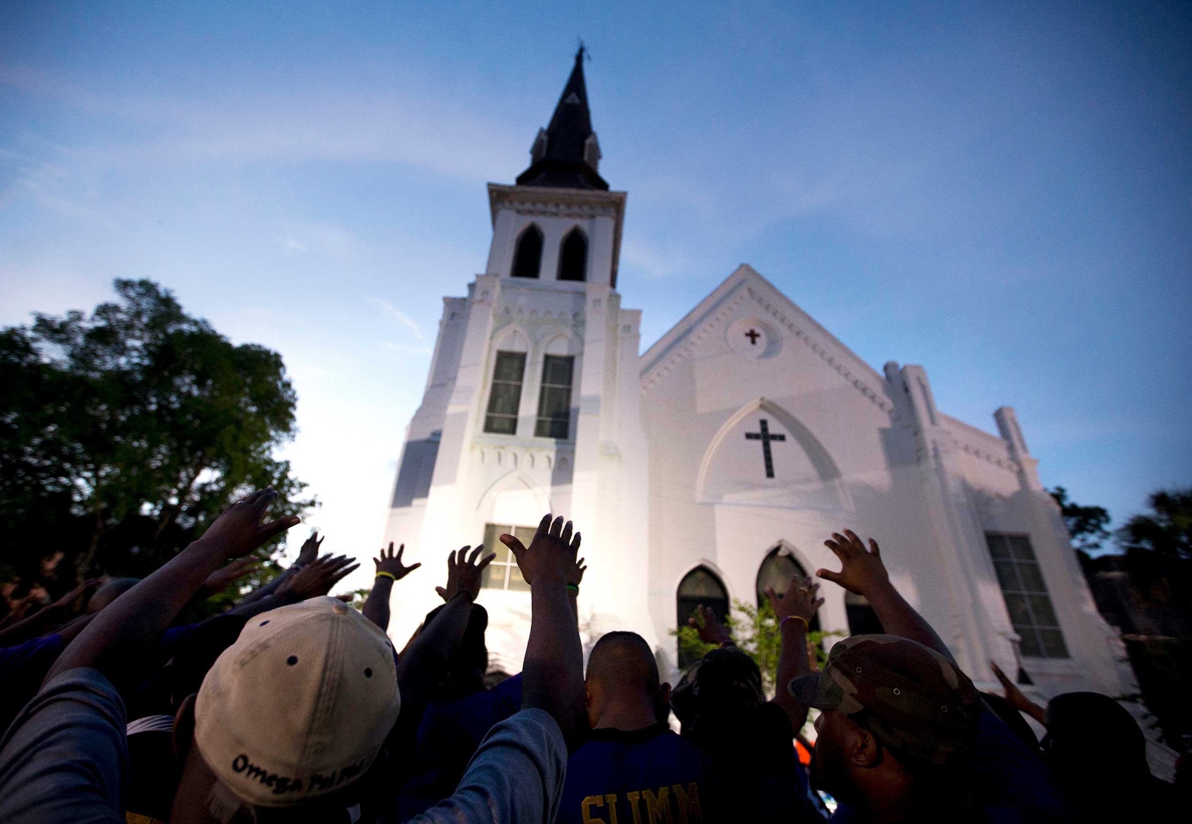A crowd prays outside the Emanuel AME Church after a memorial service for the nine people killed in a racist attack at the church in Charleston, S.C., June 19, 2015. (Stephen B. Morton—AP)