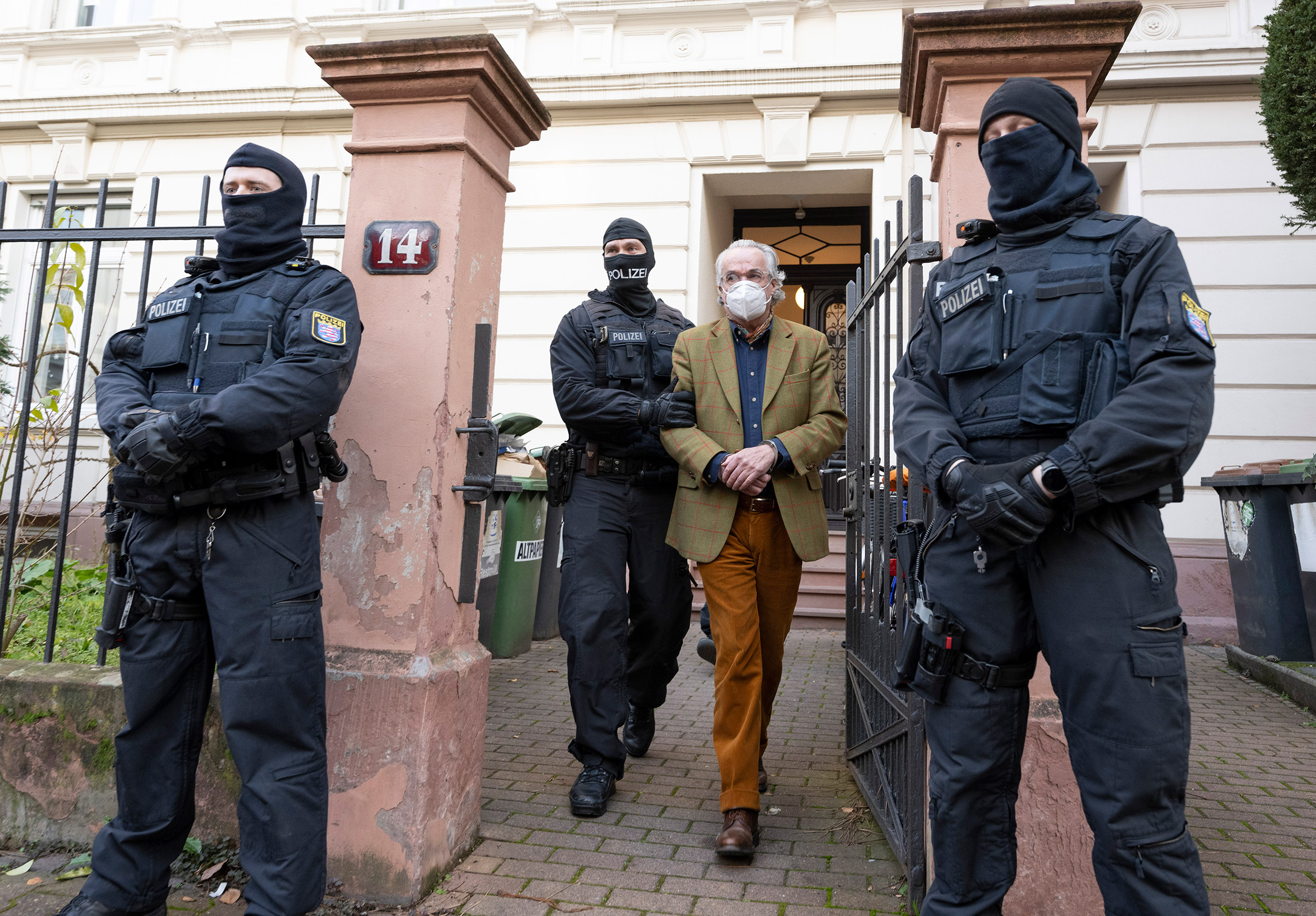 Police officers lead Heinrich XIII Prince Reuss to a police vehicle during a raid in Frankfurt, Germany on Dec. 7, 2022. (Boris Roessler—picture-alliance/dpa/AP)