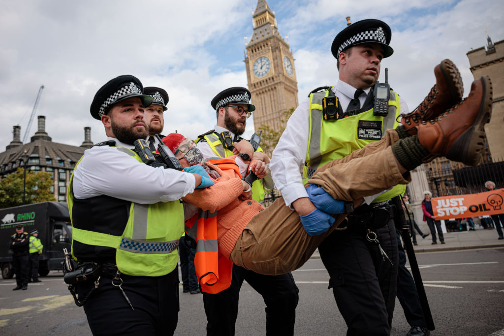 Police officers arrest an Insulate Britain protester at Parliament Square on October 12, 2022 in London, England. (Rob Pinney—Getty Images)