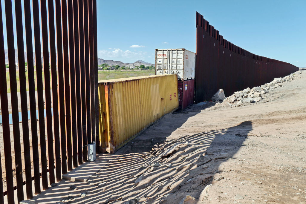 Shipping containers block a void in the wall as that prevent migrants attempting to cross in to the U.S. from Mexico at the border Aug. 19, 2022 in San Luis, Arizona. (Photo by Nick Ut—Getty Images)