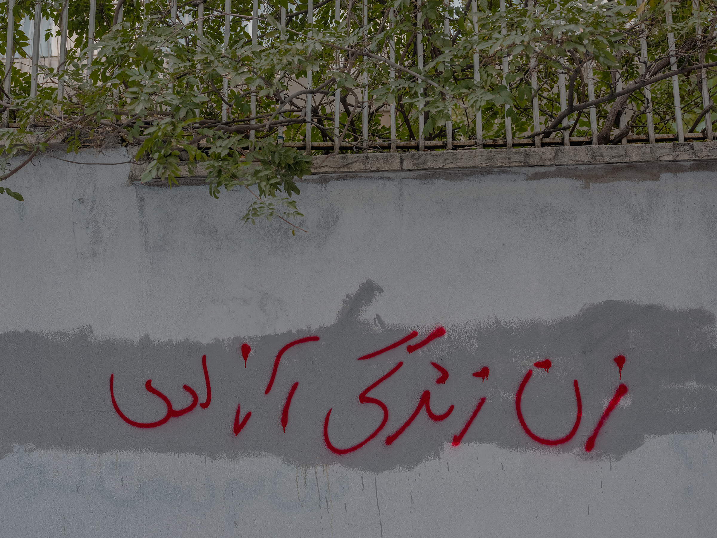 Graffiti that reads "Woman, Life, Freedom" seen on the streets of Tehran. The authorities frequently cover protest slogans up with fresh paint but demonstrators put them back. (Forough Alaei for TIME)