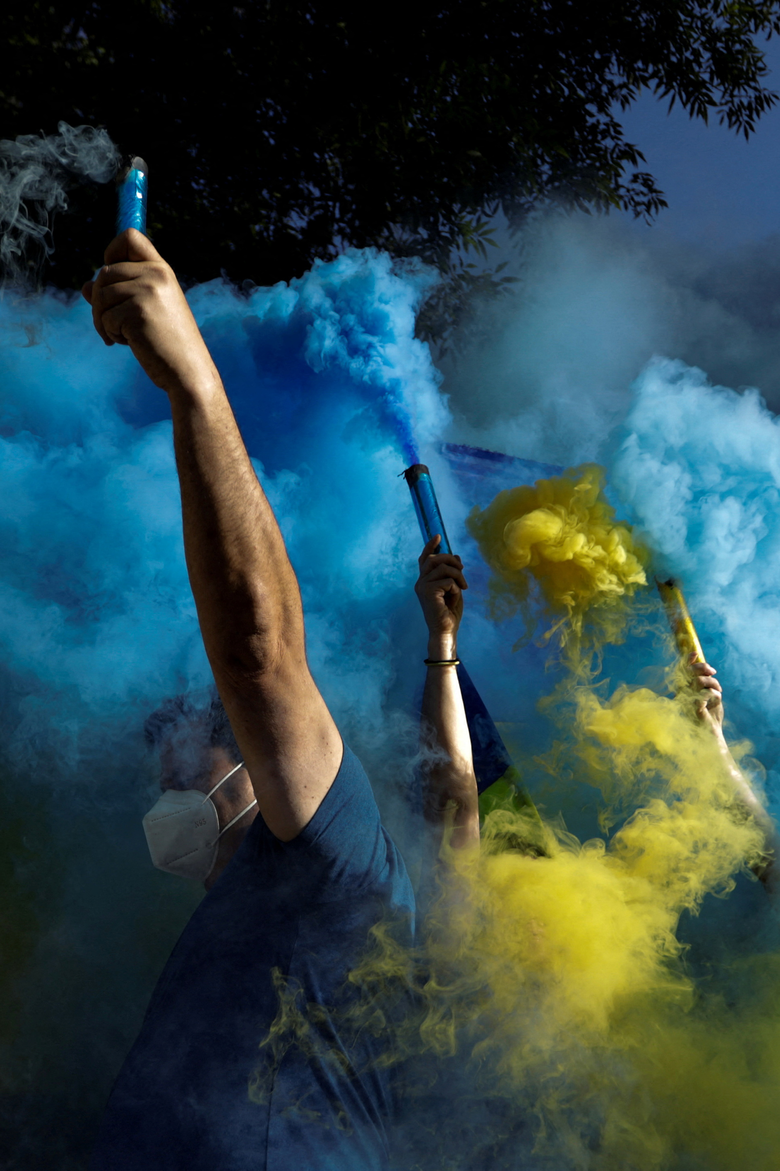 Protesters hold flares with the colors of the Ukrainian flag at an antiwar demonstration outside the Russian embassy in Mexico City on Feb. 28
