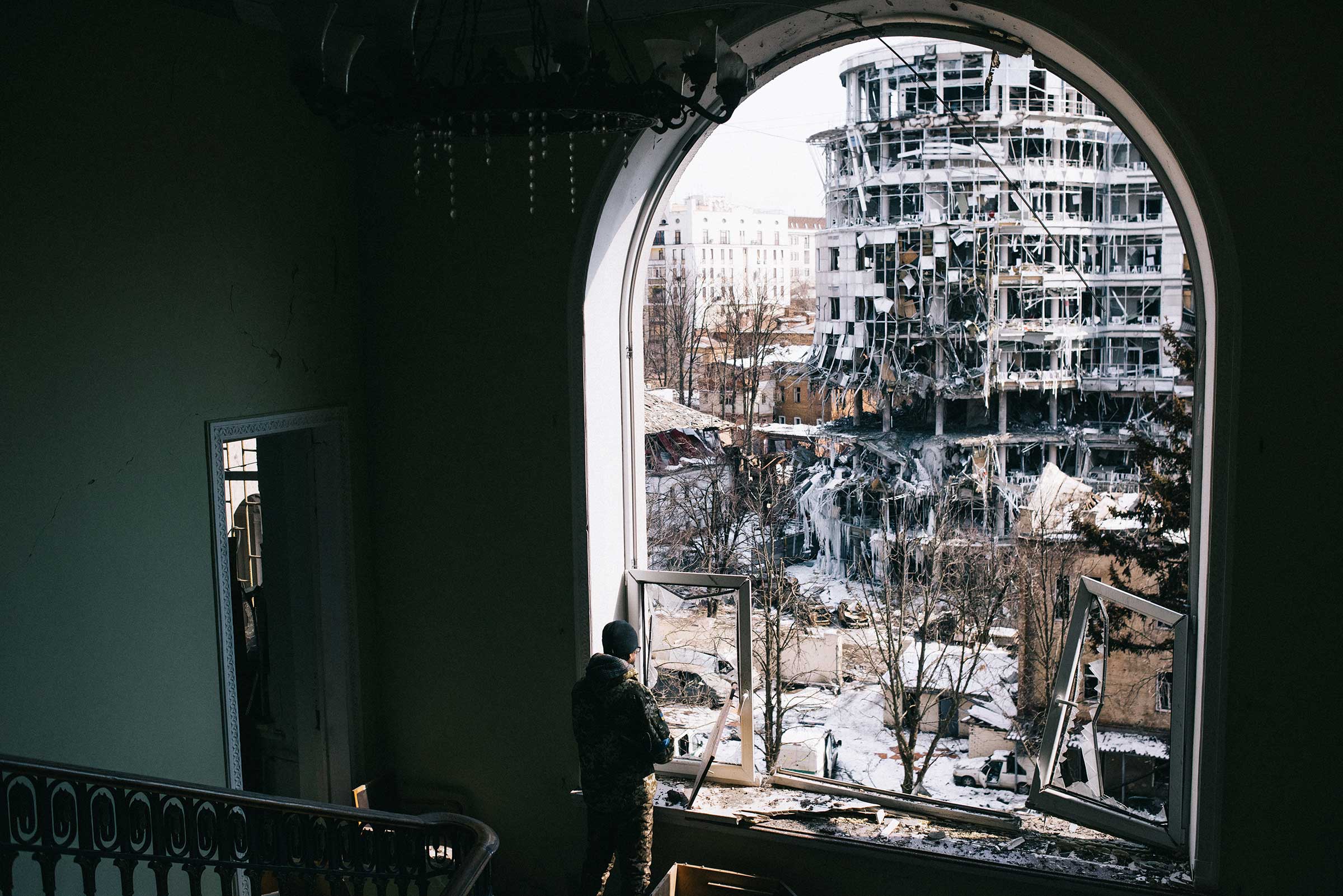A soldier observes the destruction caused by an airstrike in Kharkiv. (Maxim Dondyuk)