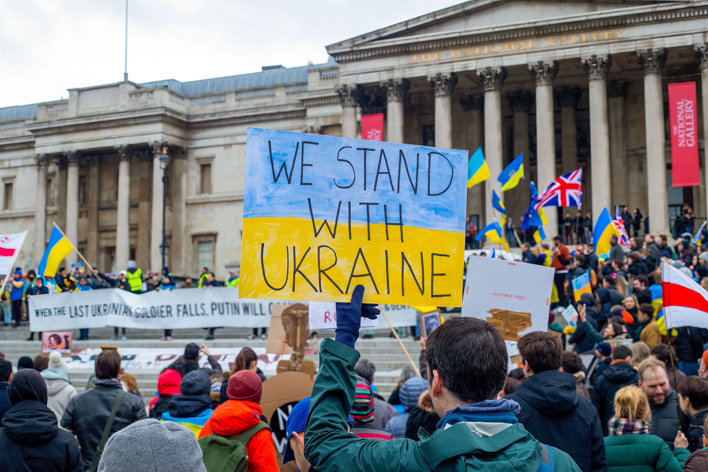 A demonstrator holds a sign saying "We Stand With Ukraine" on March 5, 2022 during a protest against Russia's invasion of Ukraine at Trafalgar Square in London. (Lucy North—SOPA Images/LightRocket/Getty Images)