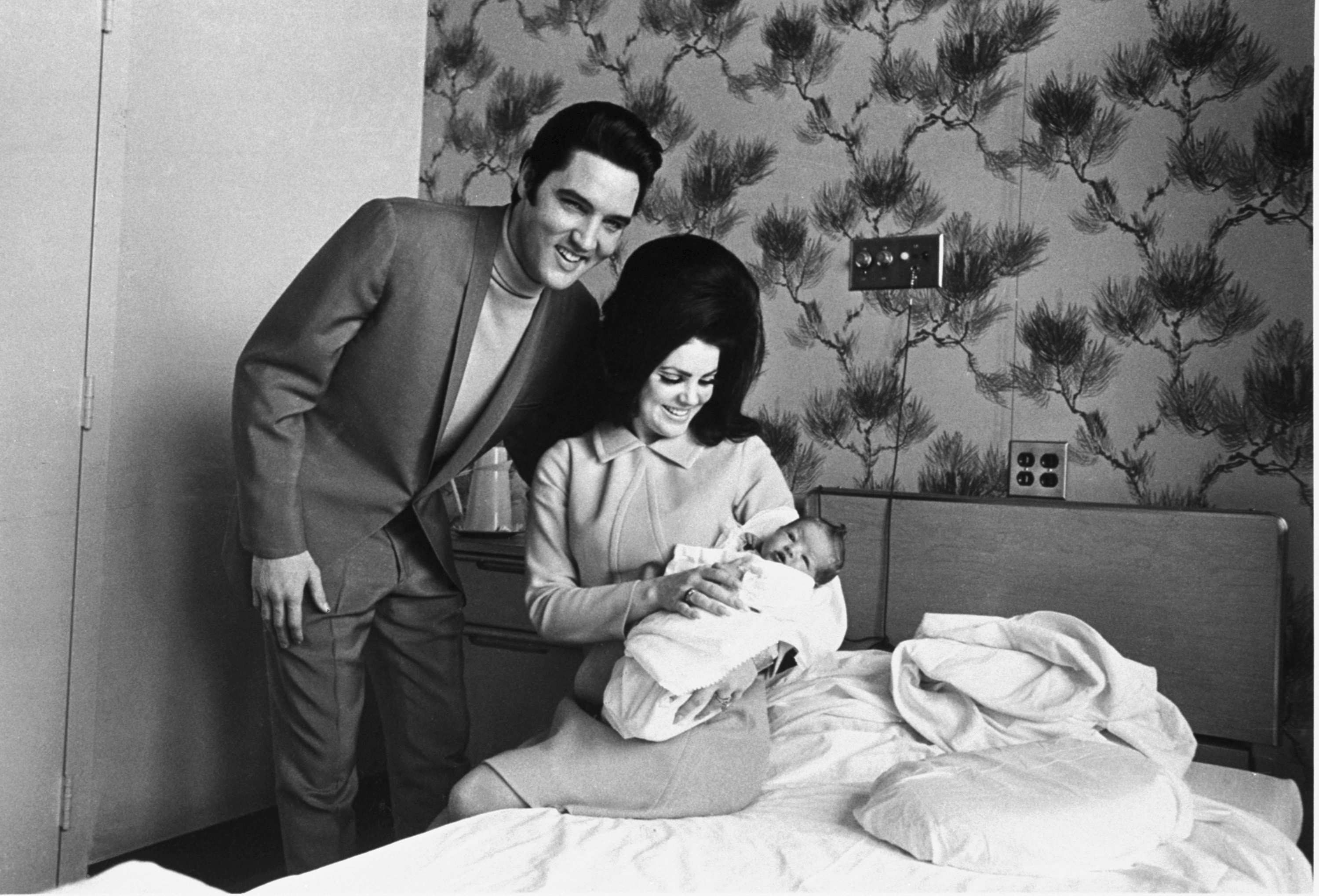 Lisa Marie Presley in the lap of her mother, Priscilla, and with her father, Elvis, on Feb. 5, 1968. (Perry Aycock—AP)