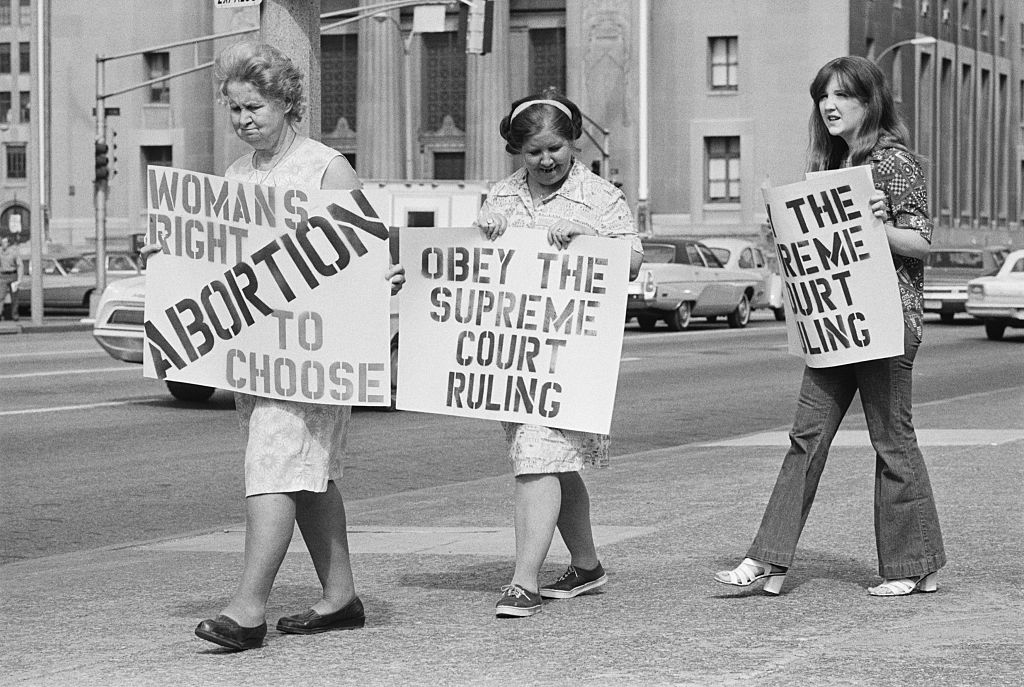 Three generations apart but together on their stand on abortion, Adelle Thomas, 67 (L), her daughter, Marie Higgins, 47 (center), and her daughter, Catherine Starr, 17 (R), join in the picket line here May, 24, 1973, which marched around City Hall.