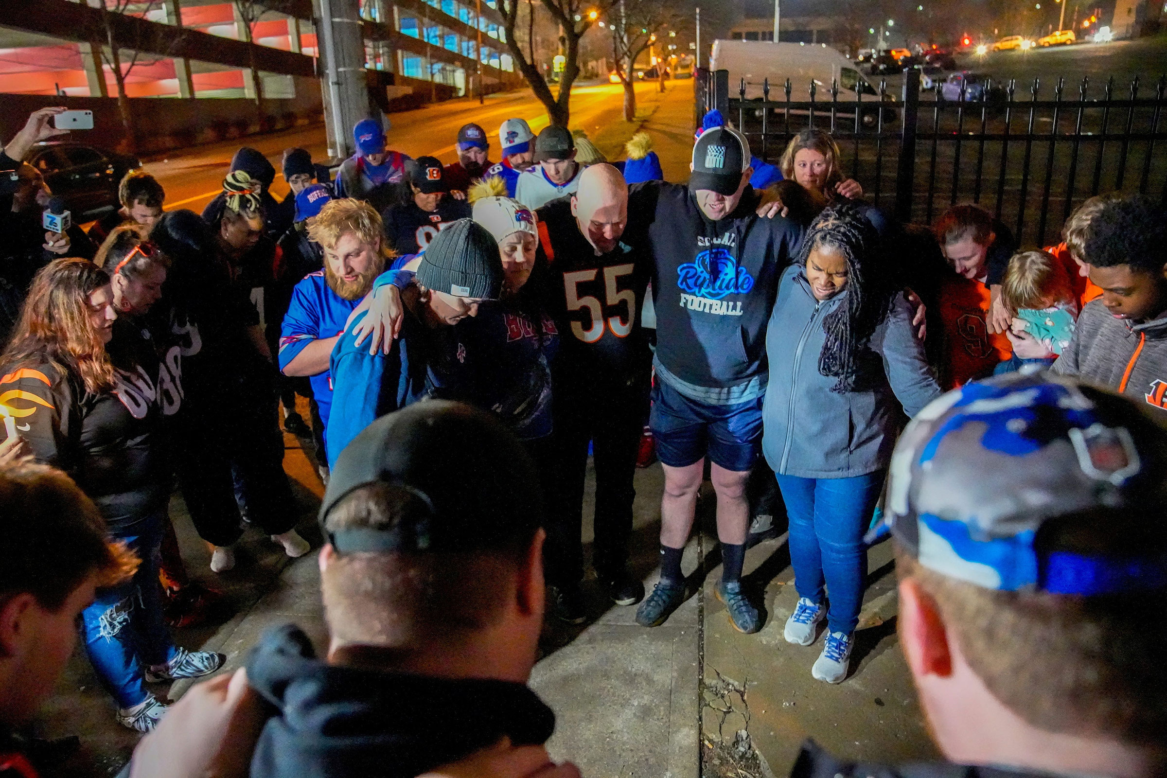 Football fans pray outside the University of Cincinnati Medical Center after Buffalo Bills defensive back Damar Hamlin collapsed on the field during the Monday Night Football NFL showdown with the Bengals in Cincinnati, Ohio, on Jan. 2, 2023. (Cara Owsley—USA Today Network/Reuters)