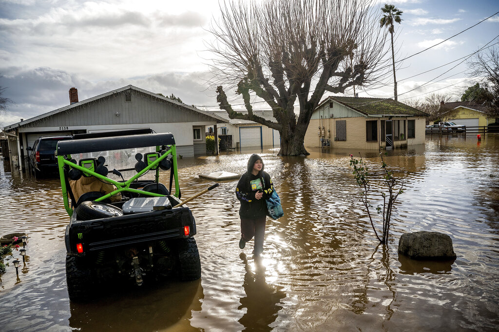 Brenda Ortega, 15, salvages items from her flooded home in Merced, Calif., on Jan. 10, 2023. (Noah Berger—AP)