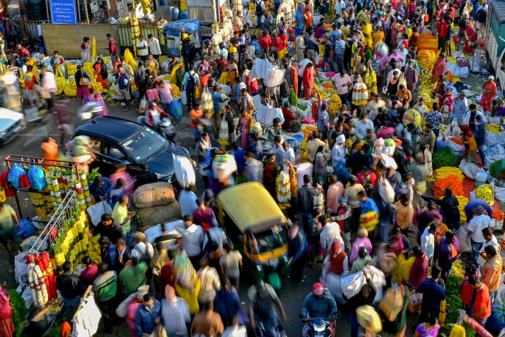 A large crowd of people walk through a market in Bangalore on October 23, 2022. (Manjunath Kiran—AFP/Getty Images)