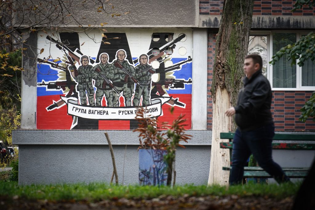 A pedestrian walks past a mural depicting the Wagner Group, reading: "Wagner Group—Russian knights" on a building's wall in Belgrade, on November 17, 2022. (Oliver Bunic—AFP/Getty Images)