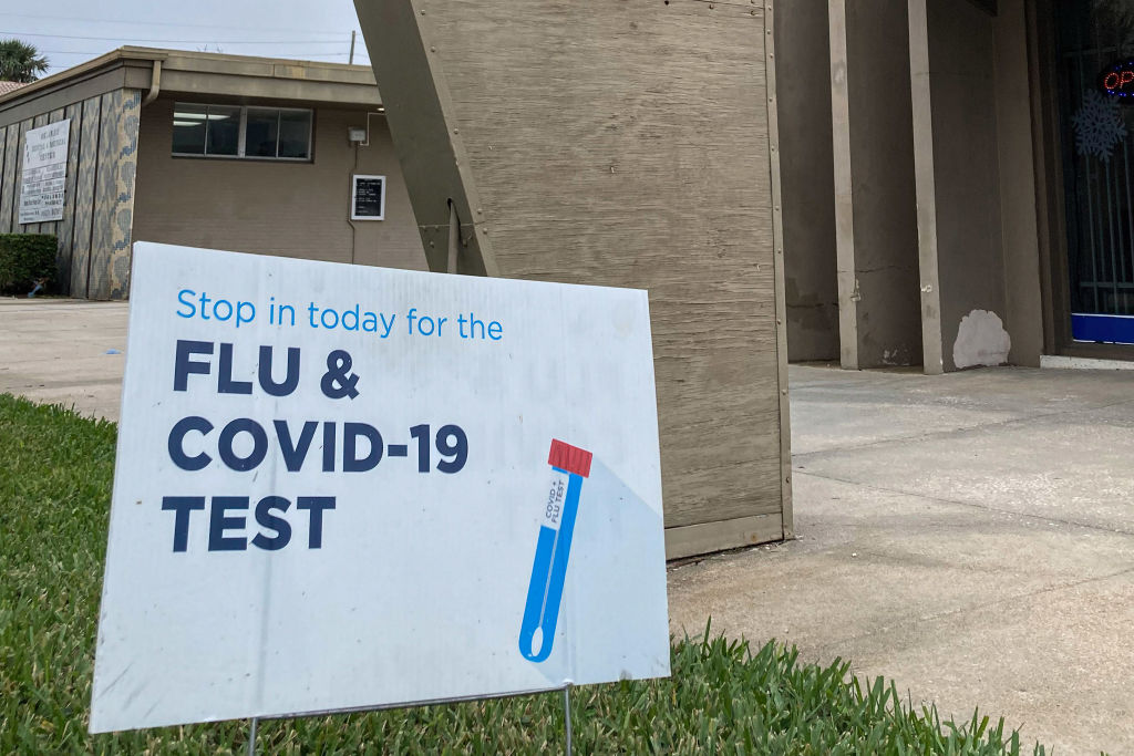 A sign advertising flu and COVID-19 testing is seen in front