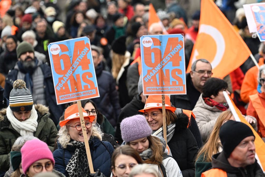 Two women holding up placards that read, "64 years, it's no" march during a nationwide strike called for by French trade unions, in Rennes, northwest France, on Jan. 19, 2023. (Damien Meyer—AFP via Getty Images)