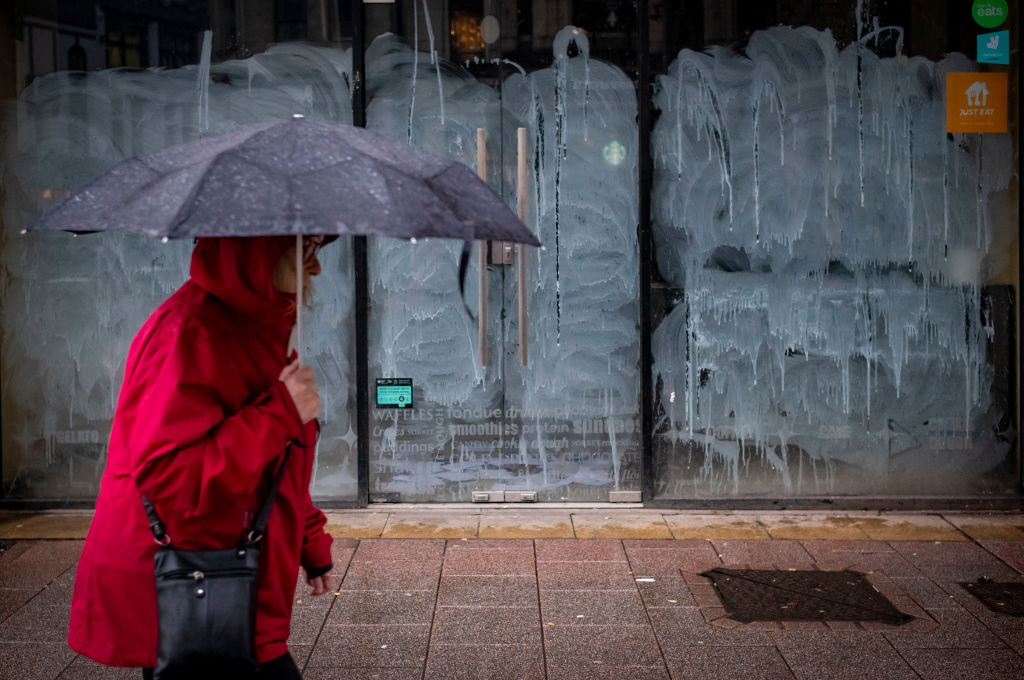 A woman walks past a closed down shop in the city centre on January 7, 2023 in Cardiff, Wales. (Matthew Horwood/Getty Images)