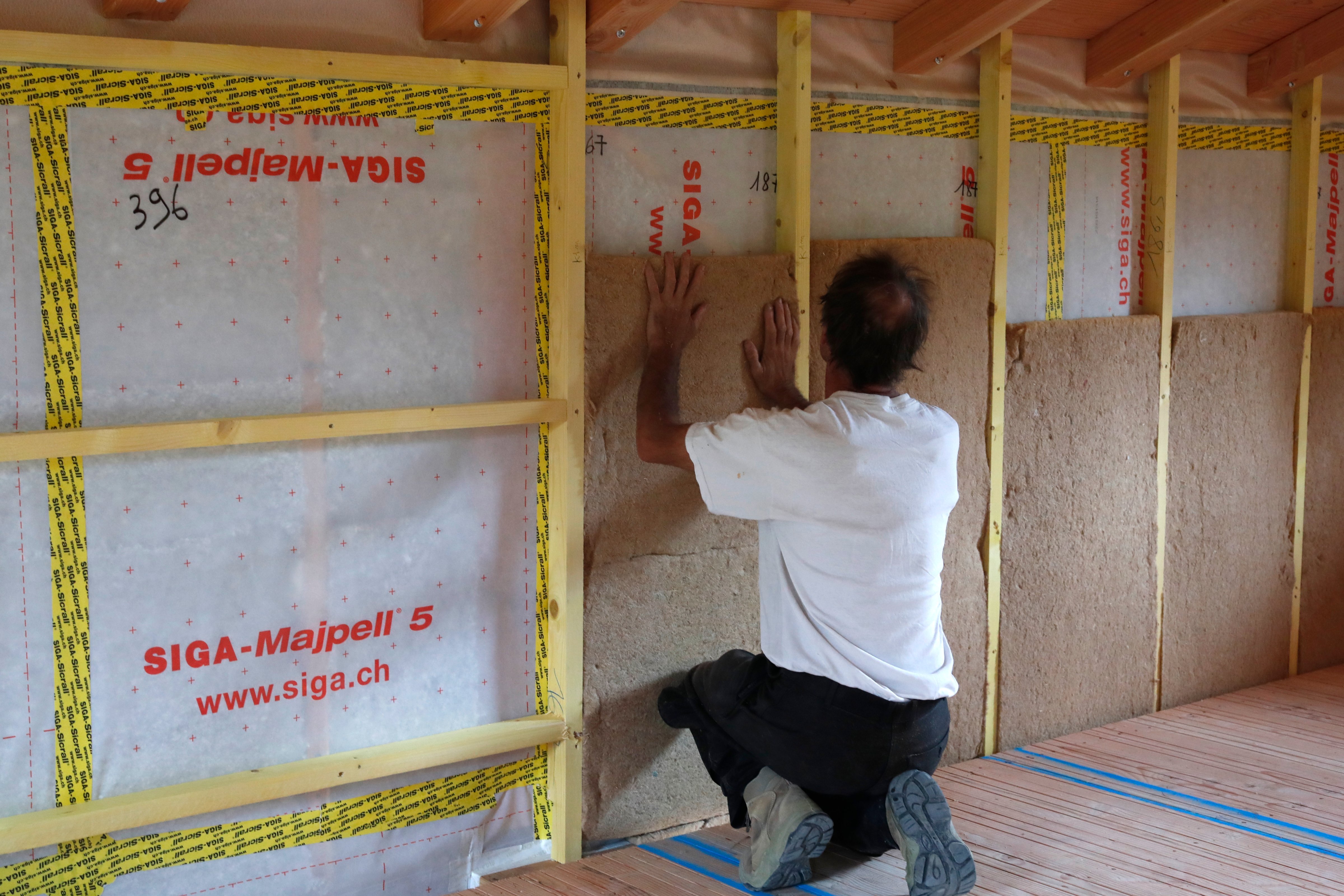 A construction worker installs insulation in a home. (Universal Images Group via Getty Images)