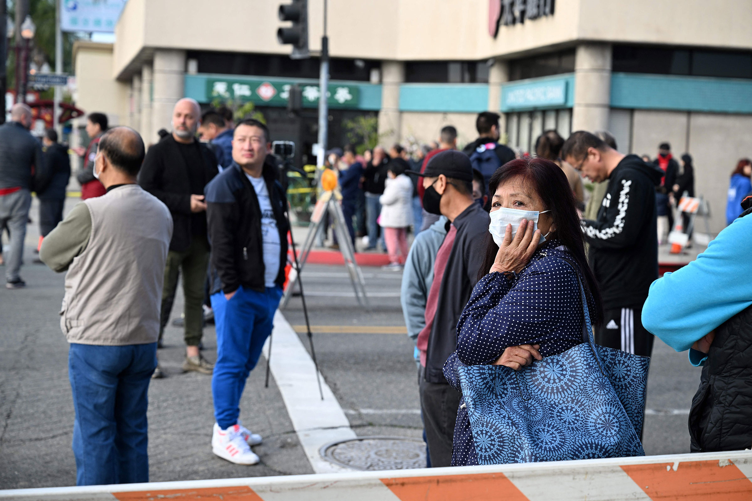 Local residents watch police investigate the scene of a mass shooting in Monterey Park, Calif., on Jan. 22, 2023. (Robyn Beck—AFP/Getty Images)