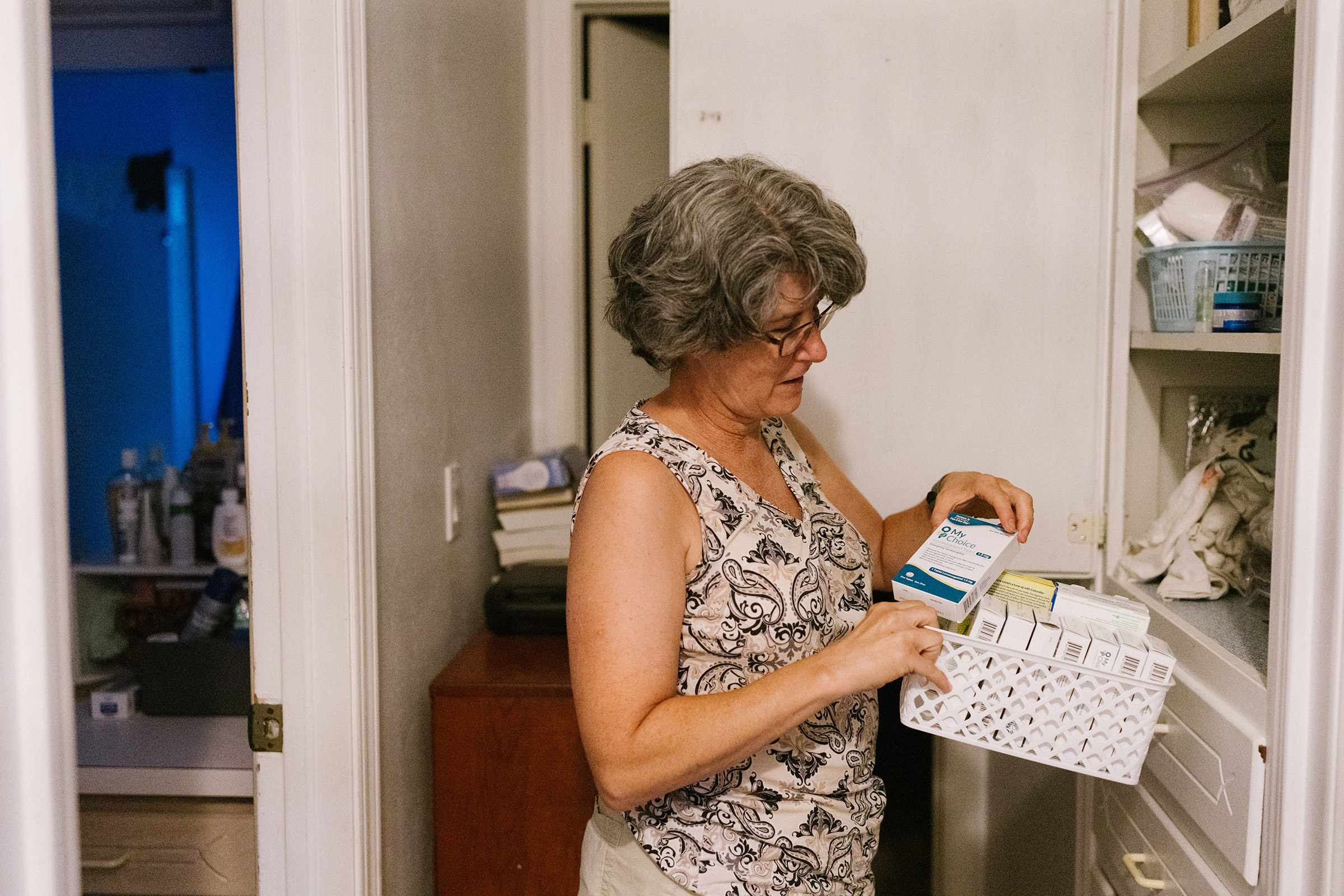 Cynthia Rogers, Ellis's mother, looks through the medicine cabinet in her home to find the morning-after pills she keeps for Ellis and her friends in case of emergencies. (Morgan Lieberman)
