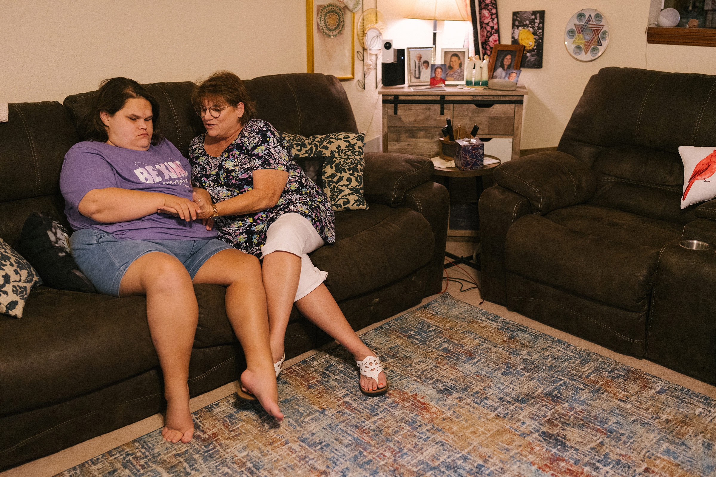 Wanda Felty sits with her daughter Kayla in their home in Norman, Okla., on July 19, 2022. Kayla's brain did not fully form in utero; she is mostly non-verbal and has significant visual impairment, among other medical issues. Felty and her husband are Kayla's primary caretakers. (Morgan Lieberman)