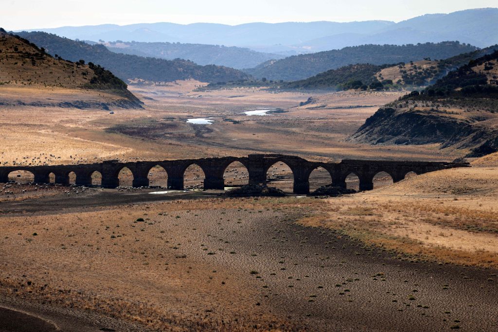 Part of the Guadiana river  dried up and gave way to dry land under the Puente de la Mesta medieval bridge in Villarta de los Montes, in the central-western Spanish region of Extremadura, on Aug. 16, 2022. (THOMAS COEX/AFP— Getty Images)