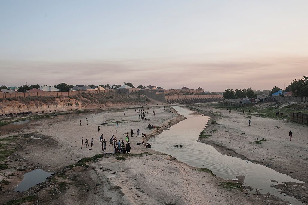 People gather in the seasonal Ngadda River that flows towards Lake Chad during the rainy season in Maiduguri in northeastern Nigeria on Dec. 6, 2016. (STEFAN HEUNIS/AFP—Getty Images)