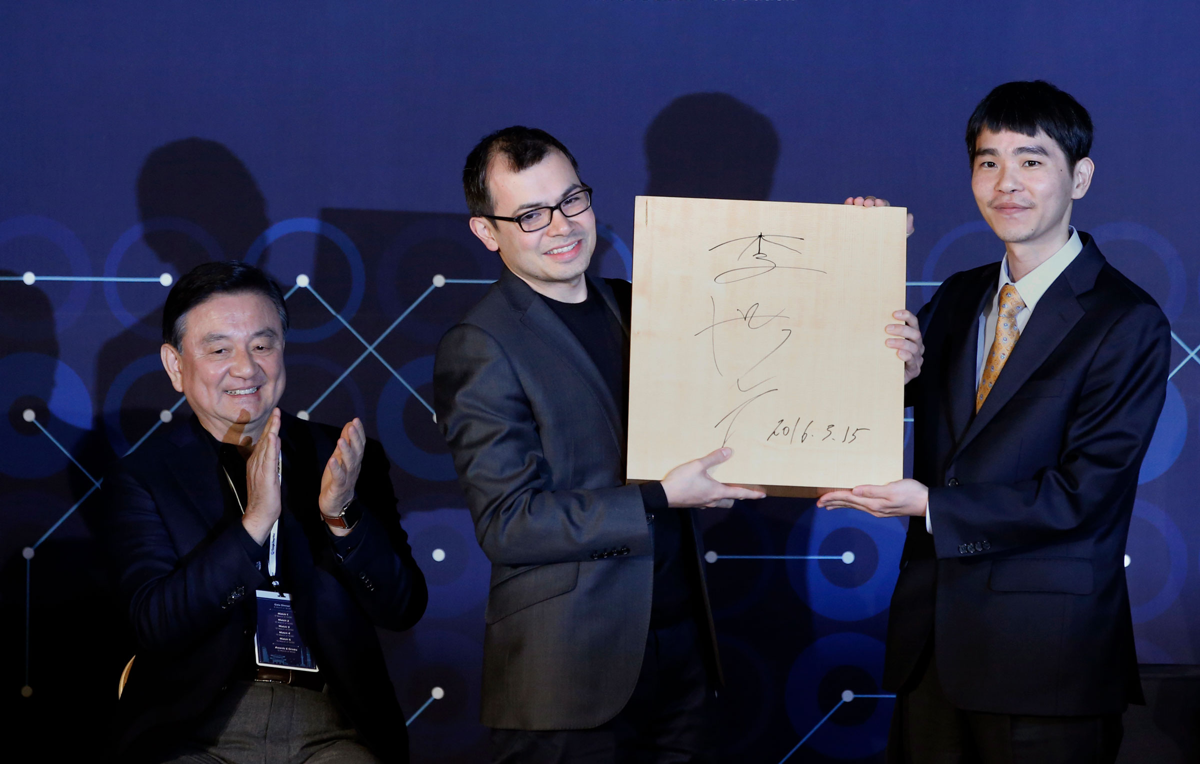 Hassabis celebrates DeepMind’s victory over Go player Lee Sedol, right, in South Korea in 2016 (Lee Jin-man—AP)