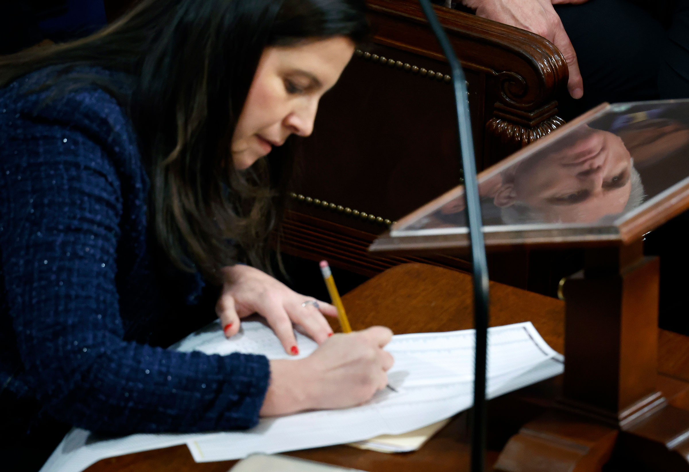 The face of House Republican Leader Kevin McCarthy is seen reflected as Rep. Elise Stefanik tallies votes in the House Chamber during the third day of elections for Speaker of the House on Jan. 5, 2023. (Chip Somodevilla—Getty Images)