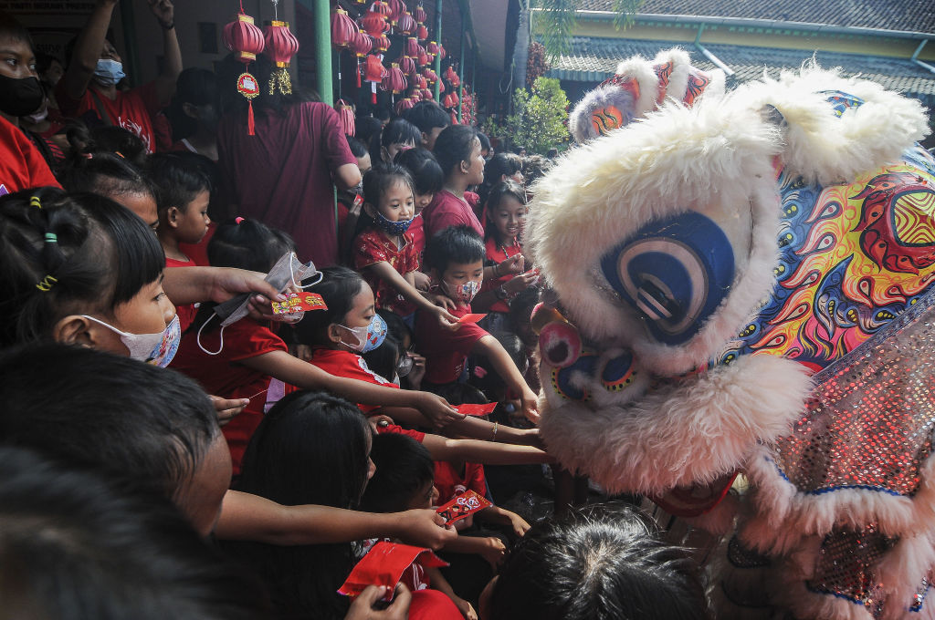 Students put little red envelopes containing small money as gifts, known locally as "ang pao", into the mouth of the "barongsai", or lion dance during Lunar New Year celebrations at a school in Solo, Central Java, Indonesia, on Jan. 19, 2023. This year, Lunar New Year—the Year of the Water Rabbit—begins on Jan. 22.