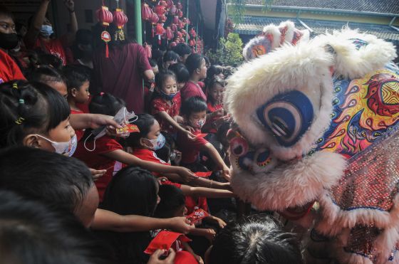Students put little red envelopes containing small money as gifts, known locally as "ang pao", into the mouth of the "barongsai", or lion dance during Lunar New Year celebrations at a school in Solo, Central Java, Indonesia, on Jan. 19, 2023. This year, Lunar New Yearâthe Year of the Water Rabbitâbegins on Jan. 22.