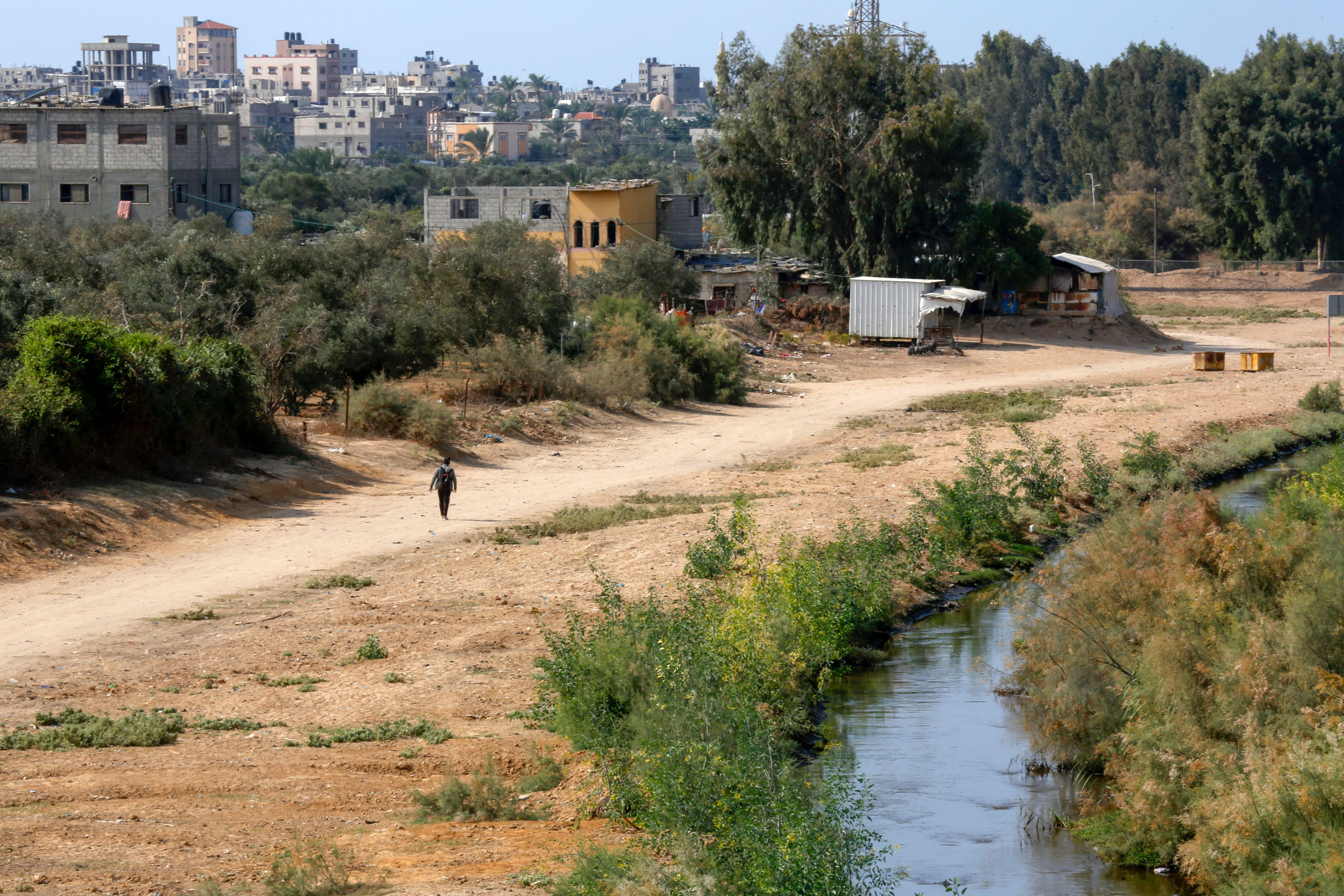 A Palestinian schoolboy stands near a wastewater channel that runs through the Gaza valley in Al-Mograqa village in Gaza on Nov. 6, 2022. (Ahmed Zakot—SOPA Images/LightRocket/Getty Images)