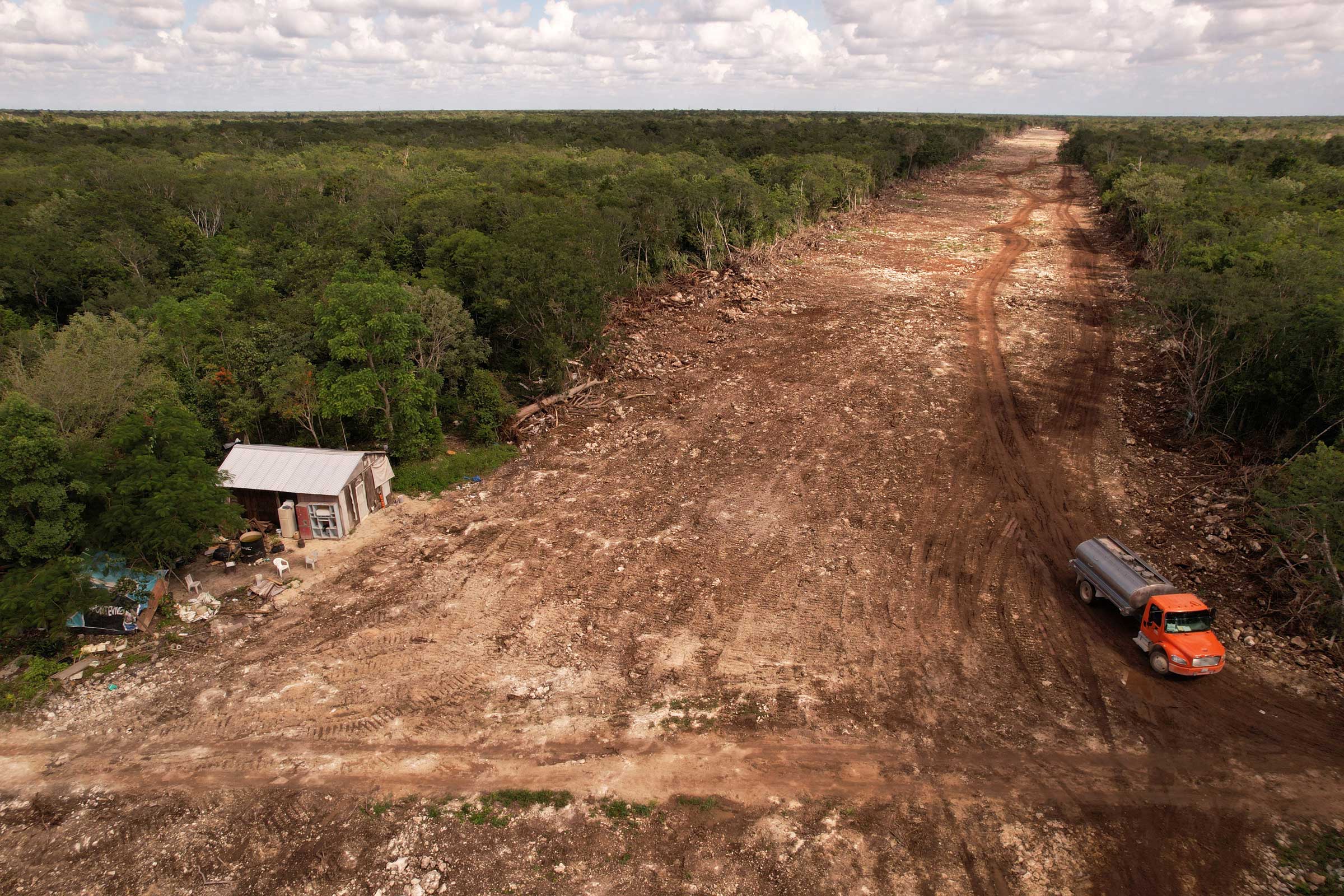 A house stands on the edge of forest which has been cleared for construction of section 5 of the new Mayan Train route, in Solidaridad, Quintana Roo, Mexico on Nov. 6, 2022. (Jose Luis Gonzalez—Reuters)