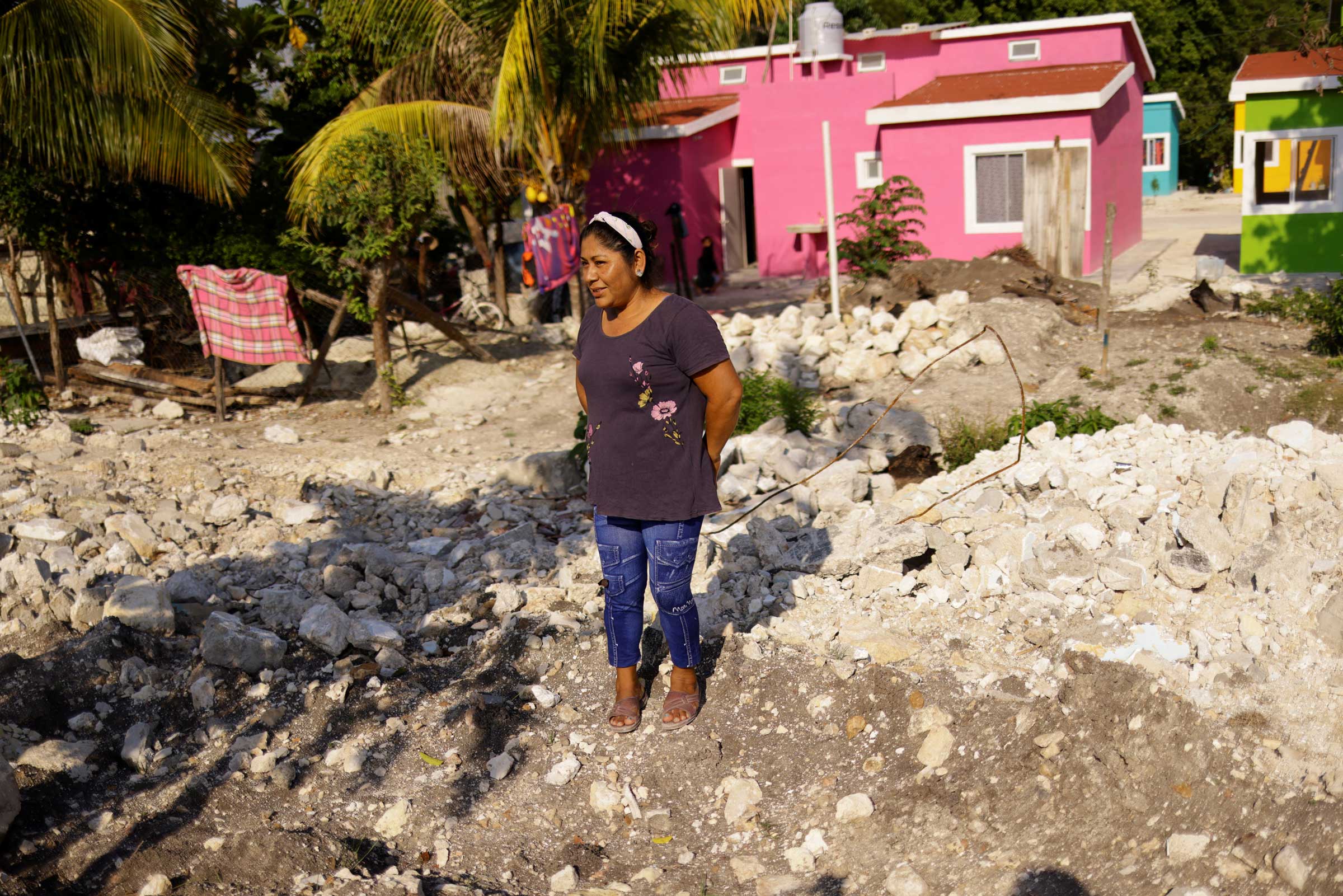 Rosario Jimenez stands in front of her new house after being relocated due to the construction of section 1 of the new Mayan Train route, in the town of Haro, Mexico, on May 12, 2022. Jimenez says she was upset when her house was demolished, but is happy she has been relocated into a newly built home further back from the train tracks. (Jose Luis Gonzalez—Reuters)