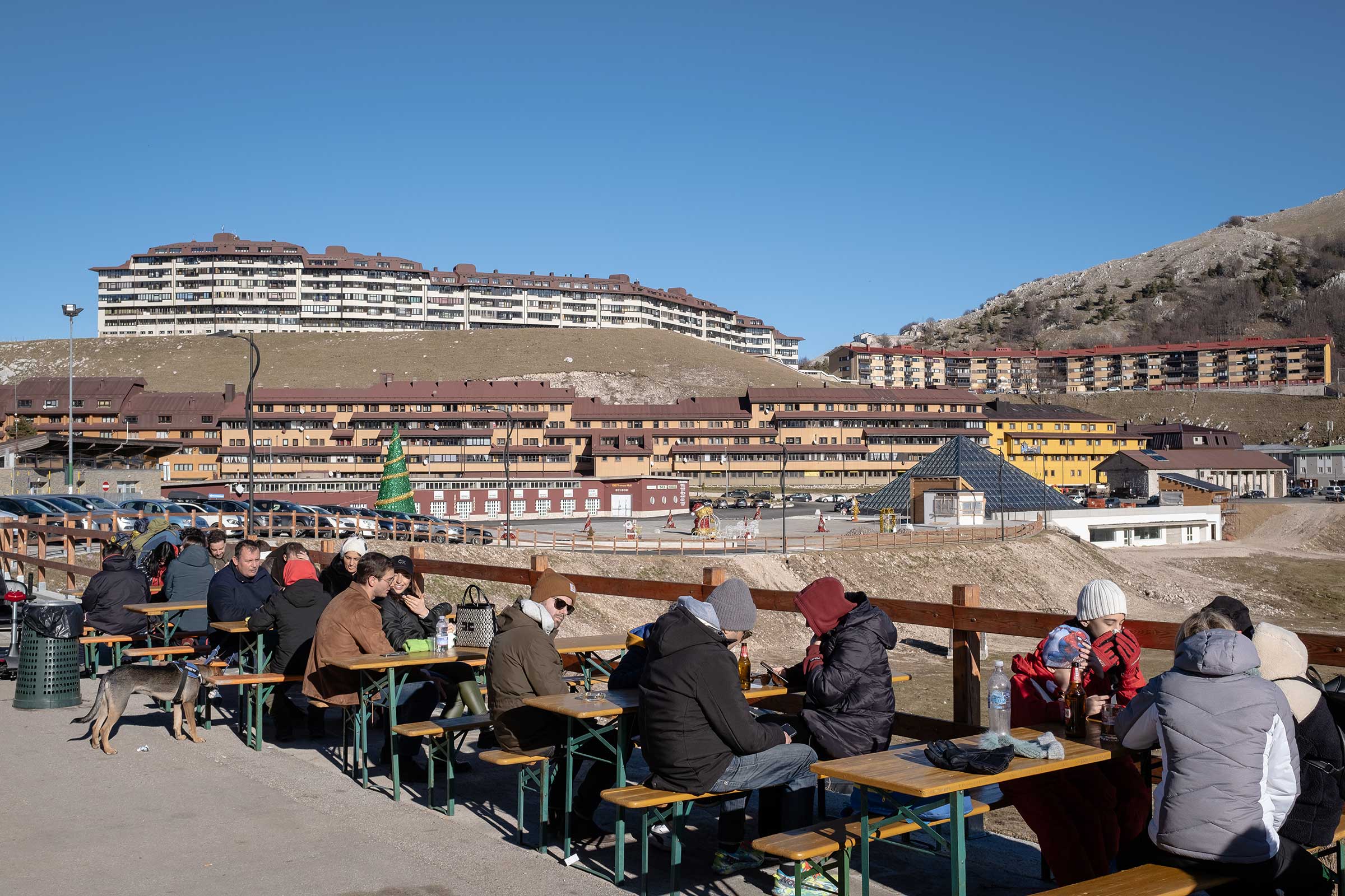 Tourists eat lunch outside the Campitello Matese ski resort, which was closed to skiing and other winter sports, in early January 2023.  (Manuel Dorati)