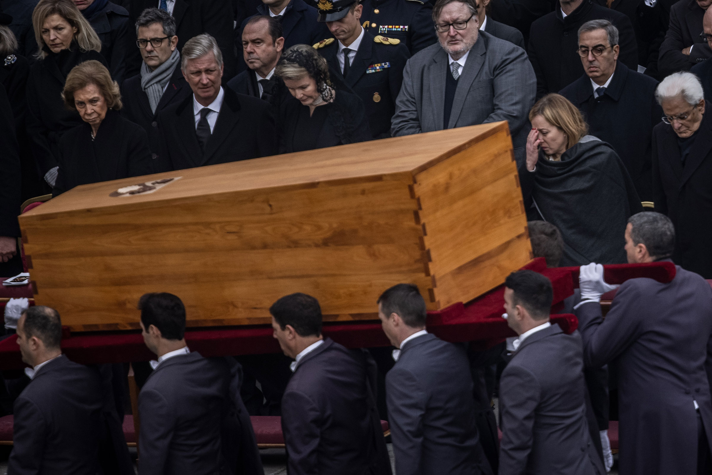 Pallbearers carry away the coffin of the late Pope Emeritus Benedict XVI after the public funeral Mass for Pope Emeritus Benedict XVI in St. Peter’s Square on Jan. 5, 2023. In the front row are (from left) Sofia, former Queen of Spain, King Philippe of Belgium, Queen Mathilde of Belgium, Giorgia Meloni (2nd from right), Prime Minister of Italy, Sergio Mattarella (right), President of Italy. (Oliver Weiken—dpa/picture alliance/Getty Images)