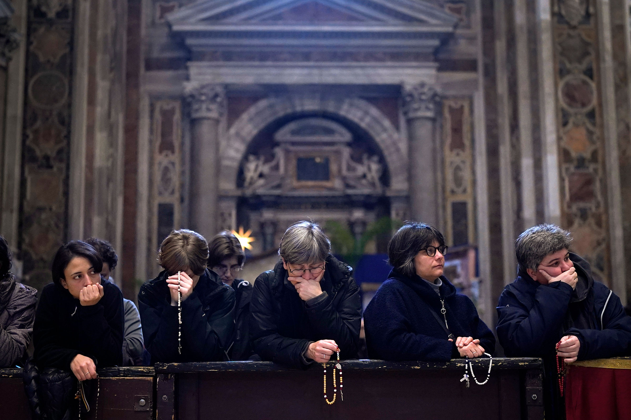 People pray as Pope Emeritus Benedict XVI lies in state at St. Peter’s Basilica on Jan. 3, 2023, in Vatican City.