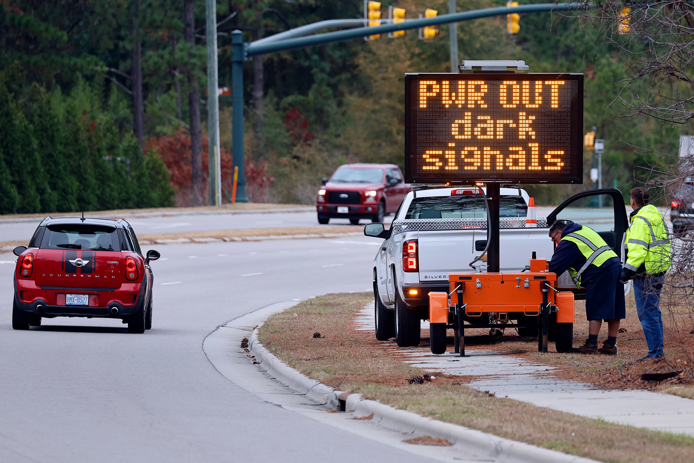 Workers set up an automated display warning drivers on NC211 of the power outage in the area and how to approach the upcoming intersections in Southern Pines, N.C., Monday, Dec. 5, 2022. (Karl B DeBlaker—AP)