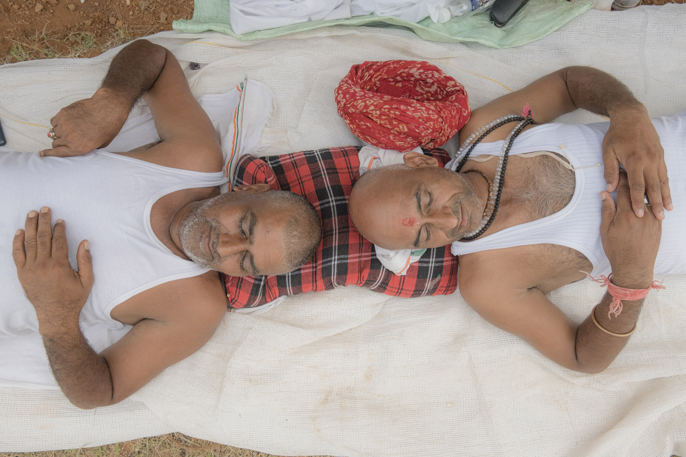 Shatrugan Sharma and Sravankumar Gujjar, from the state of Rajasthan, share a pillow while resting at a tent for the participants of the Bharat Jodo Yatra near Giriyammanahally Village in Karnataka, India, on Oct. 12, 2022. (Ronny Sen for TIME)
